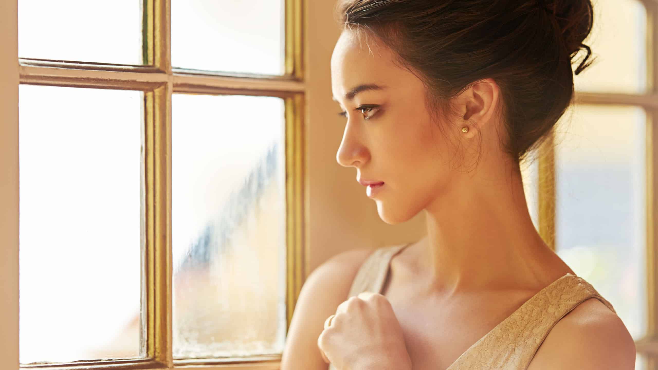 Woman, beauty and luxury in house with fancy, elegant and classy in fashion by window for wealth aesthetic. Female person, style and vintage mansion for gala, thinking or event with confidence