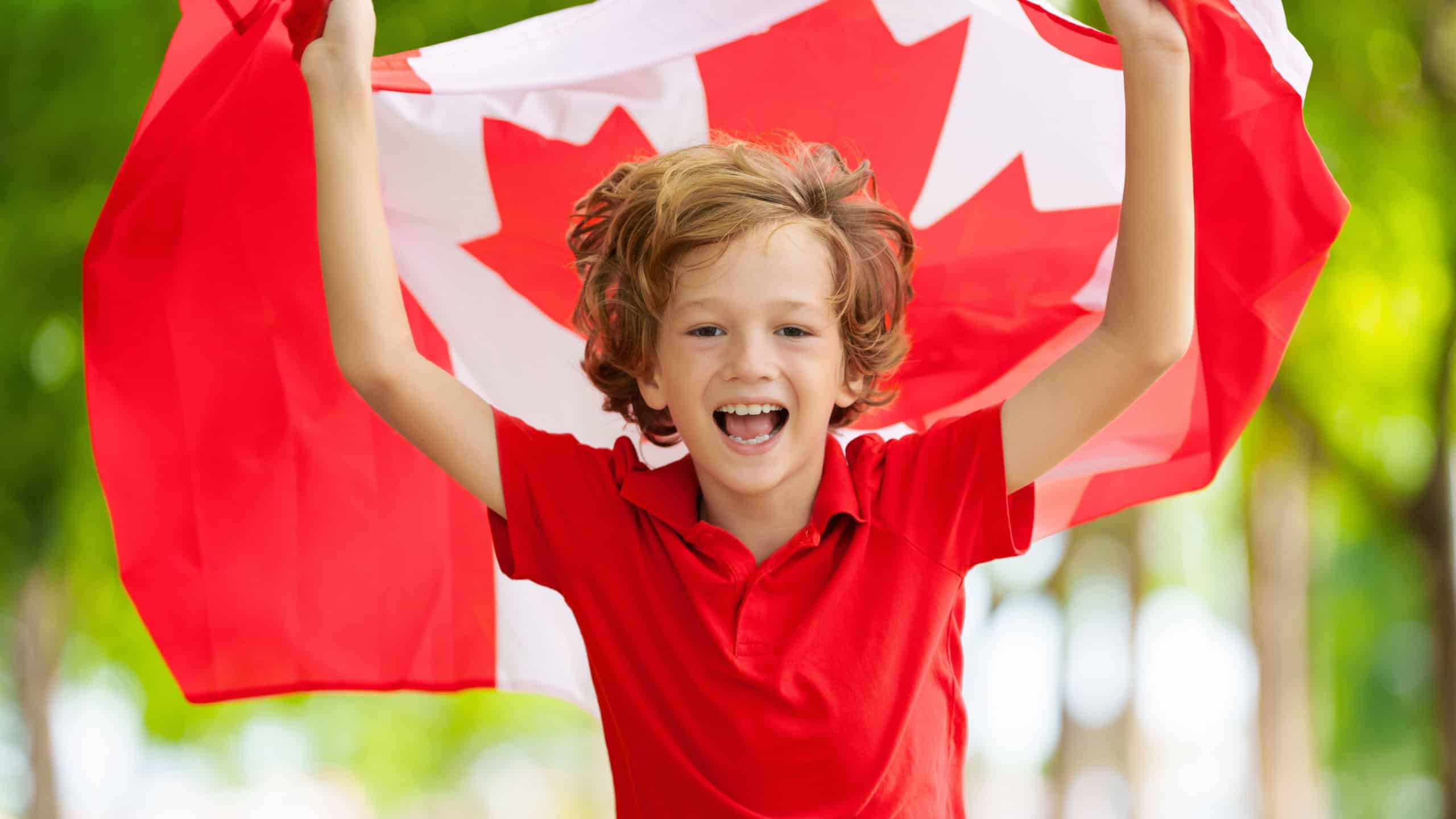 Child with Canadian flag. Happy Canada day. Little boy running with national flag cheering for Canada in football or hockey game. Canadian supporter excited after victory.