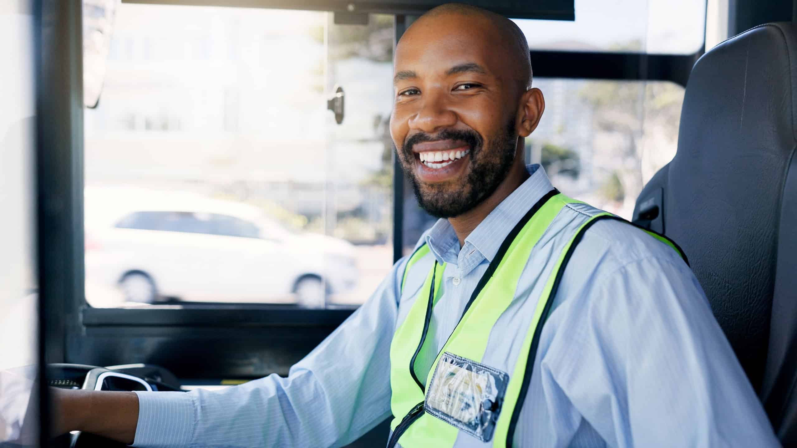 Bus driver, portrait and smile of black man at station for commute, public transportation or service. Driving, metro and uniform with happy coach conductor in vehicle for journey, tour or travel