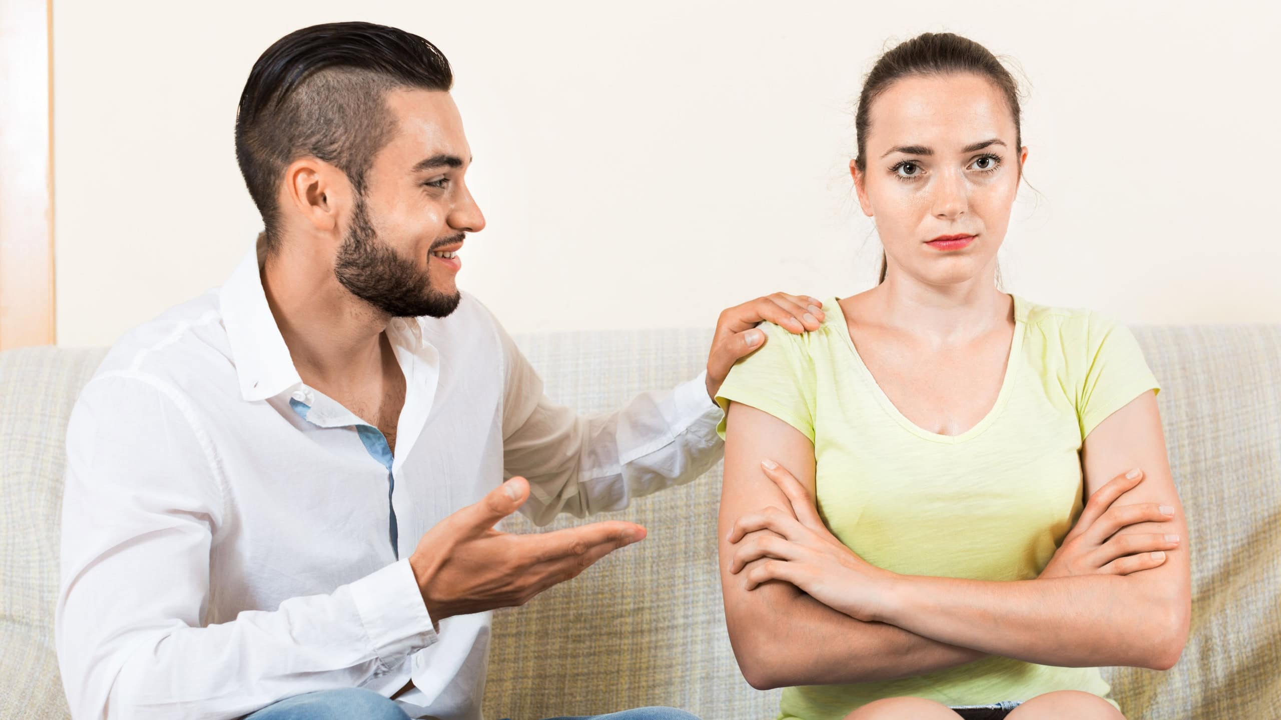 Smiling man talking to upset woman