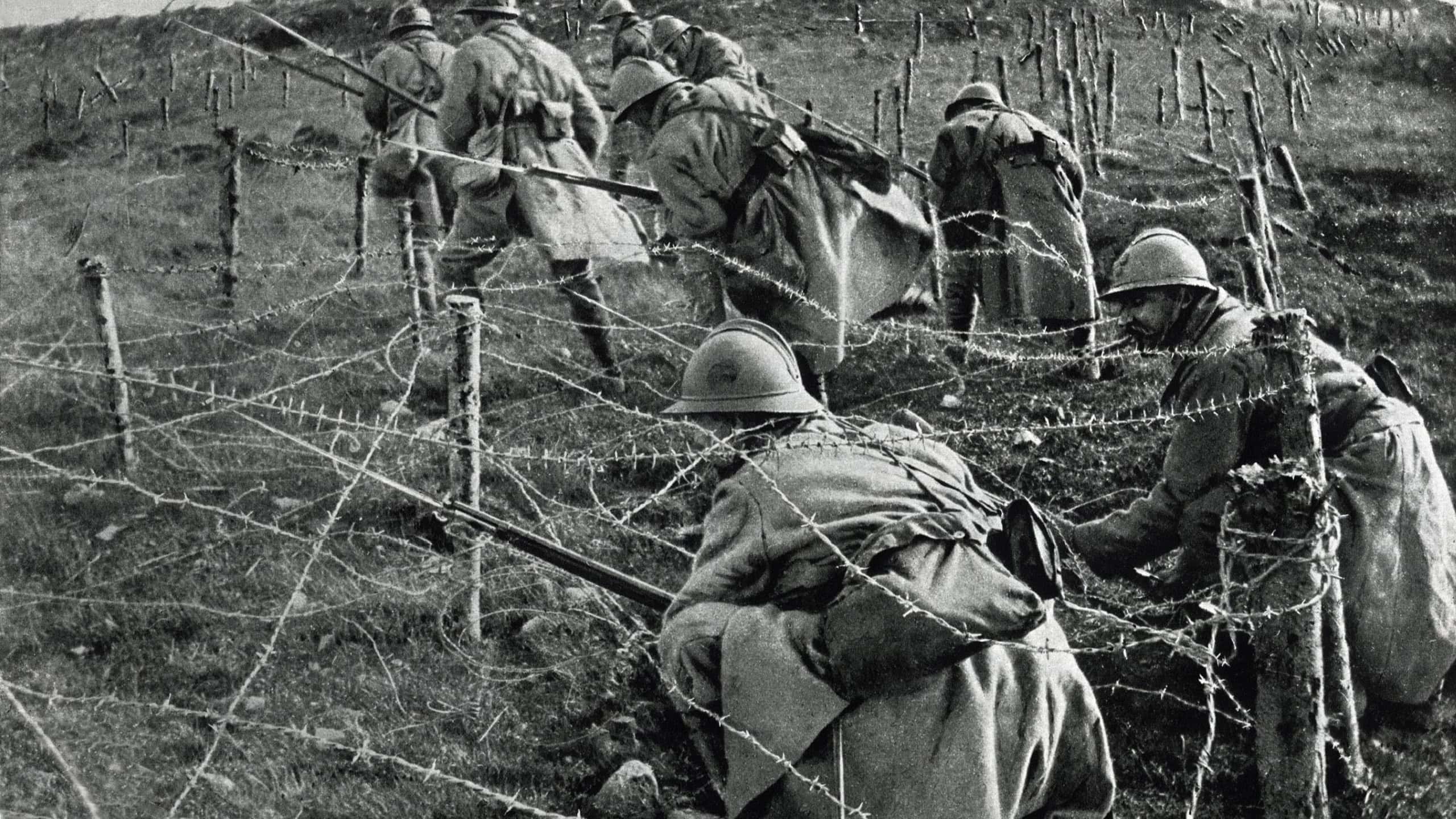 World War 1: Battle of Verdun. French soldiers crawling through their own barbed wire entanglements as they begin an attack on enemy trenches. April-June, 1916.