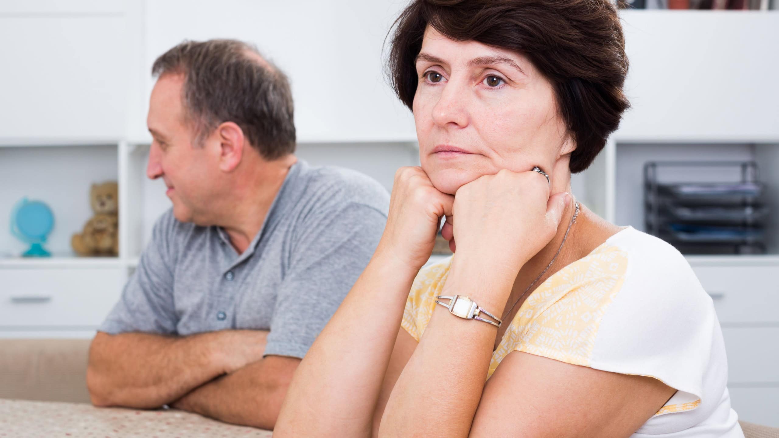 Portrait of worried mature woman having issues with her husband at home
