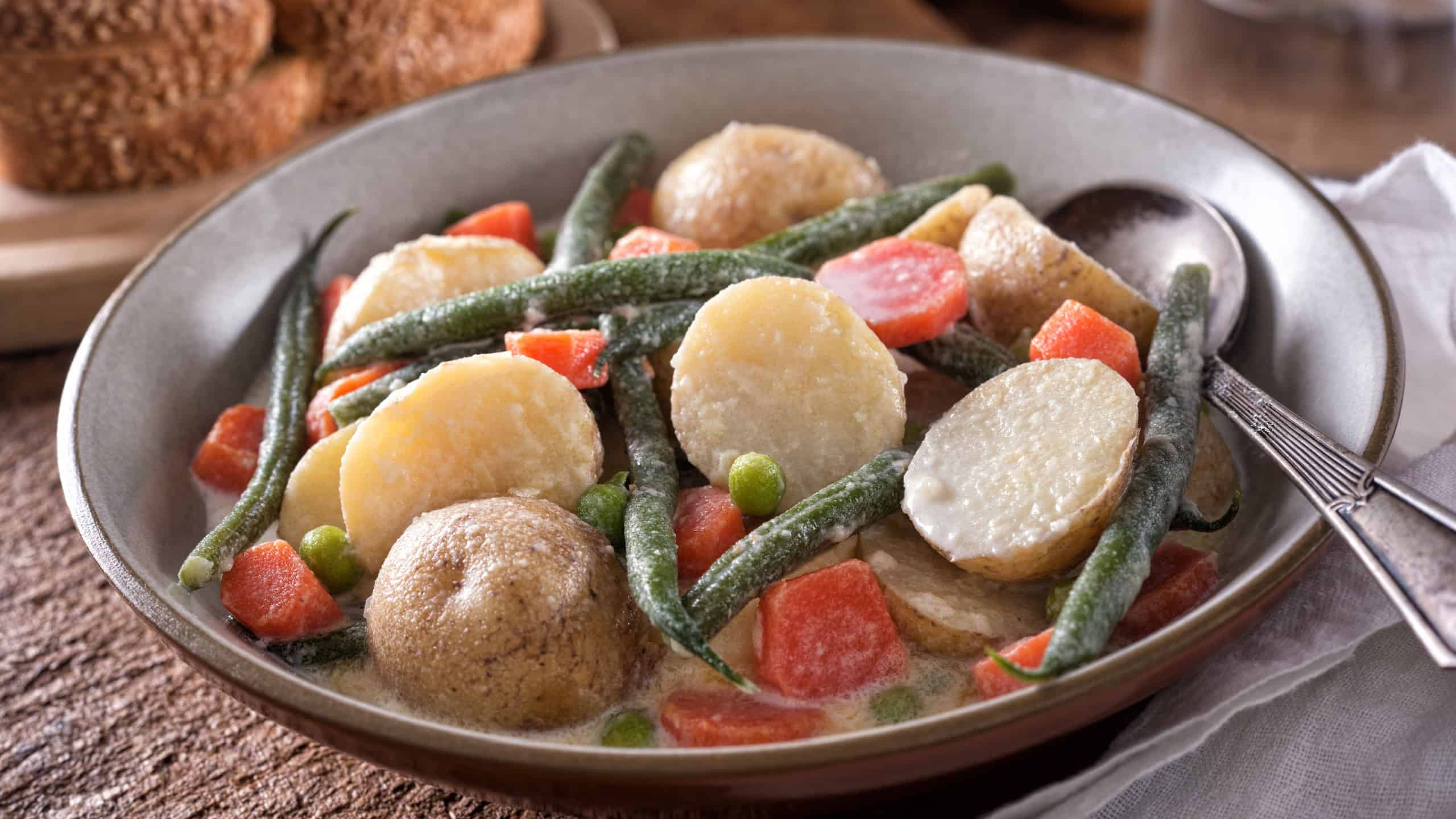 A delicious homemade Nova Scotia hodge podge vegetable stew with garden fresh potato, green beans, carrots and peas with cream.
