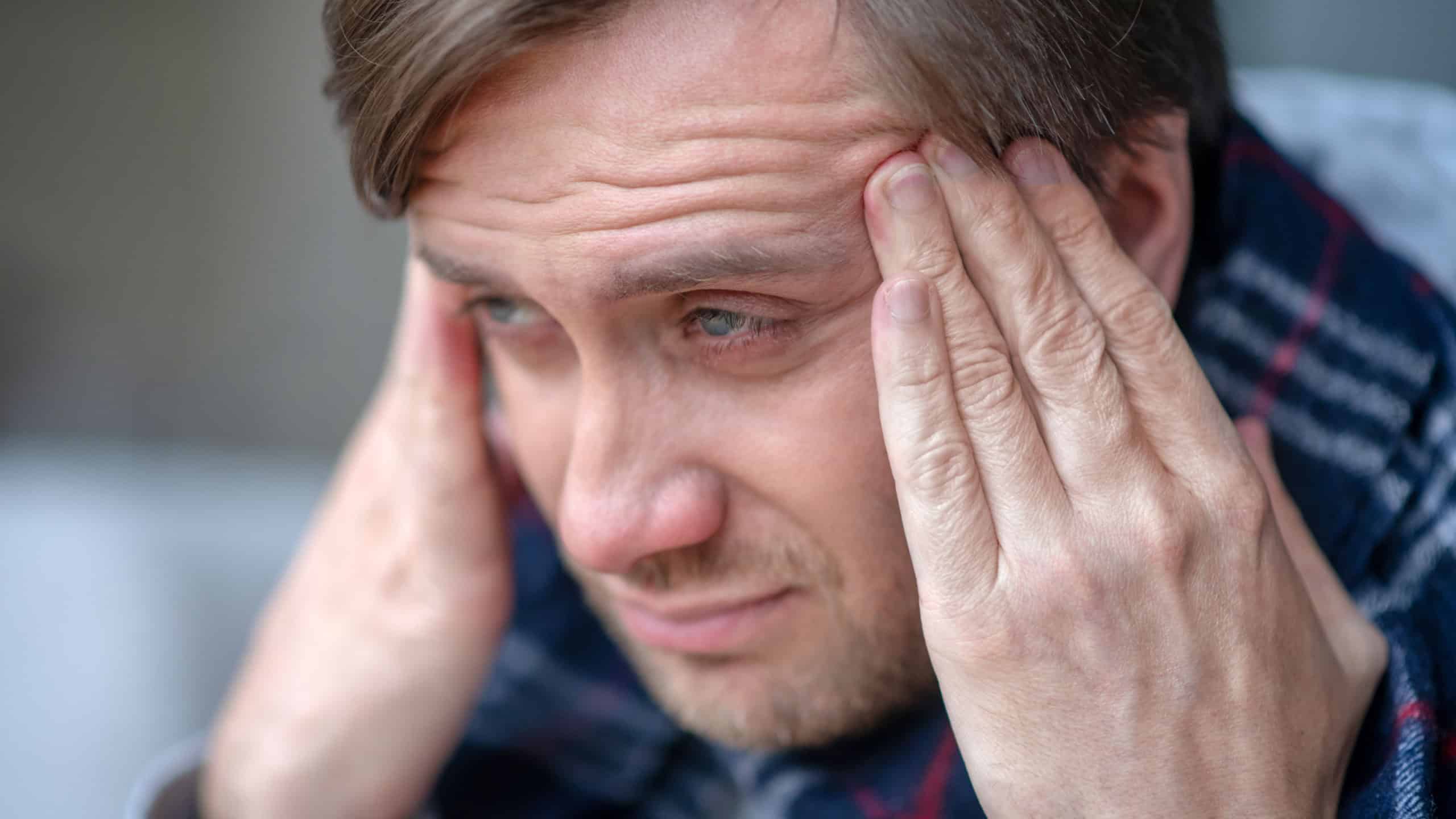 Man feeling terrible. Blue-eyed bearded man feeling terrible while having headache after catching cold