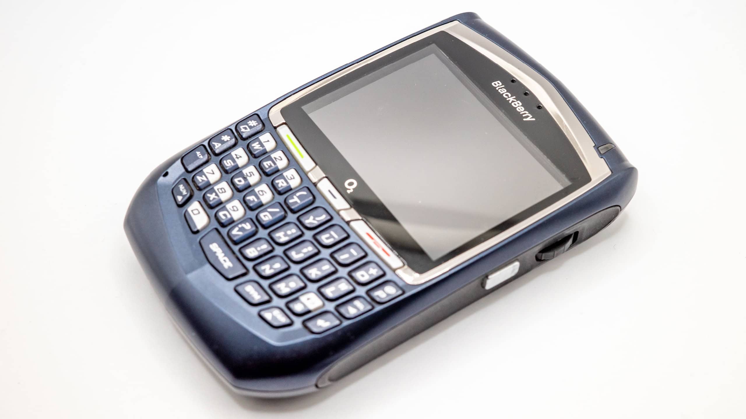 Close and selective focus on a retro Blackberry handheld PDA (now discontinued and defunct) isolated on a plain background