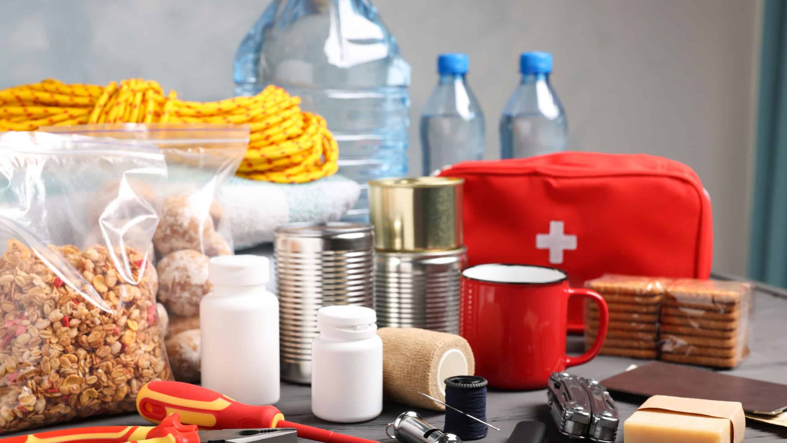 Disaster supply kit for earthquake on black wooden table indoors