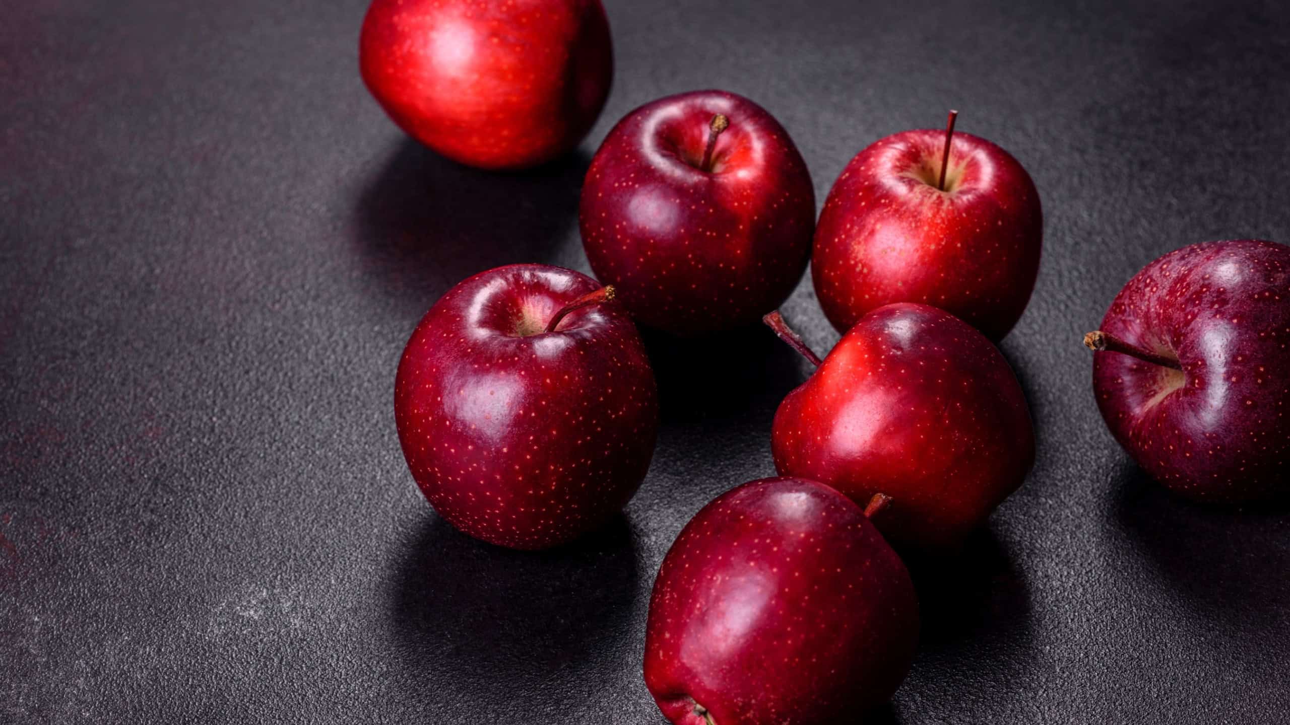 Delicious fresh apples in red on a dark concrete background. Home garden harvest