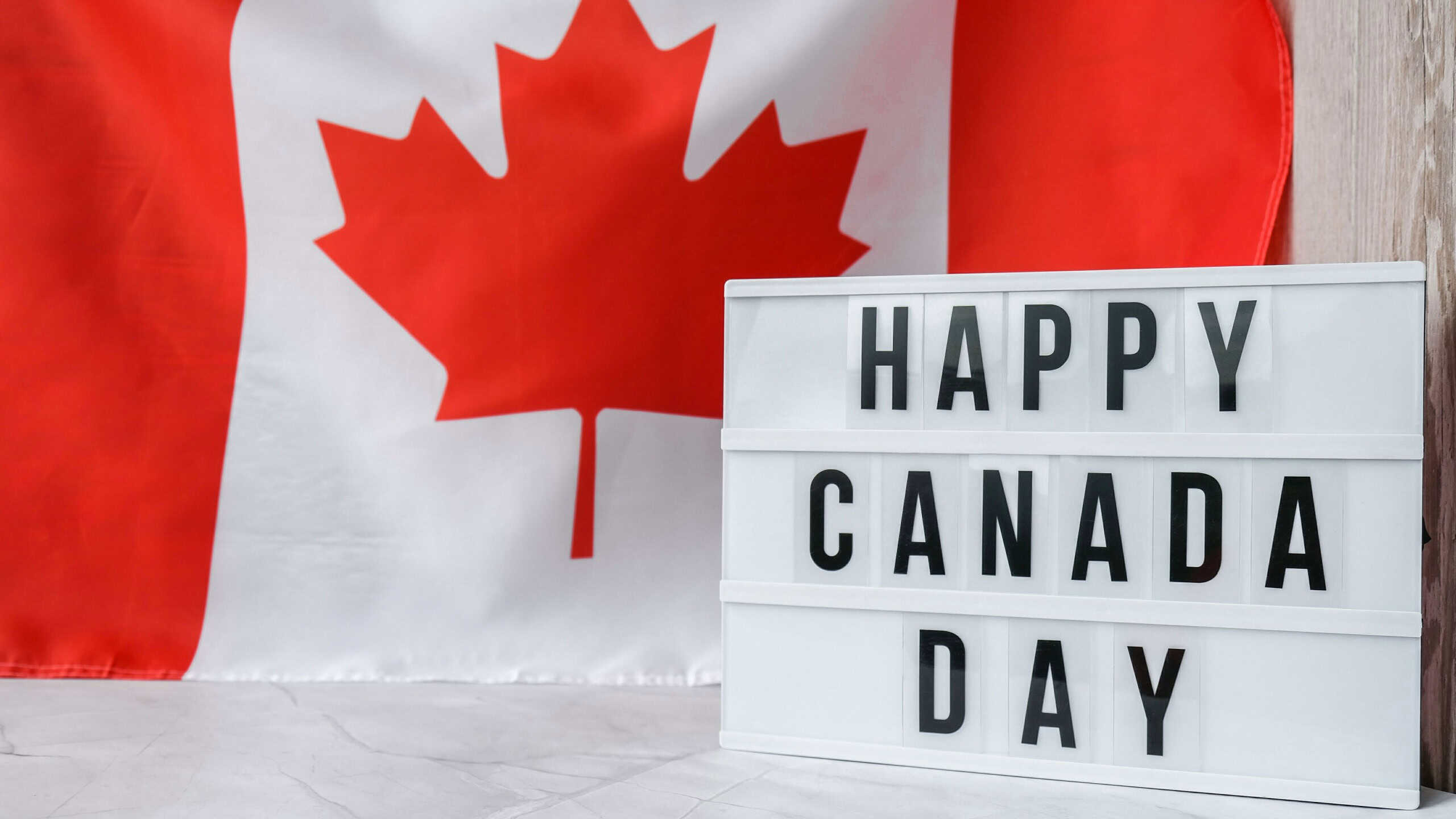 The National Flag of Canada. Lightbox with text HAPPY CANADA DAY Canadian Flag or the Maple Leaf. Patriotism. International relations concept. Independence day. Immigration