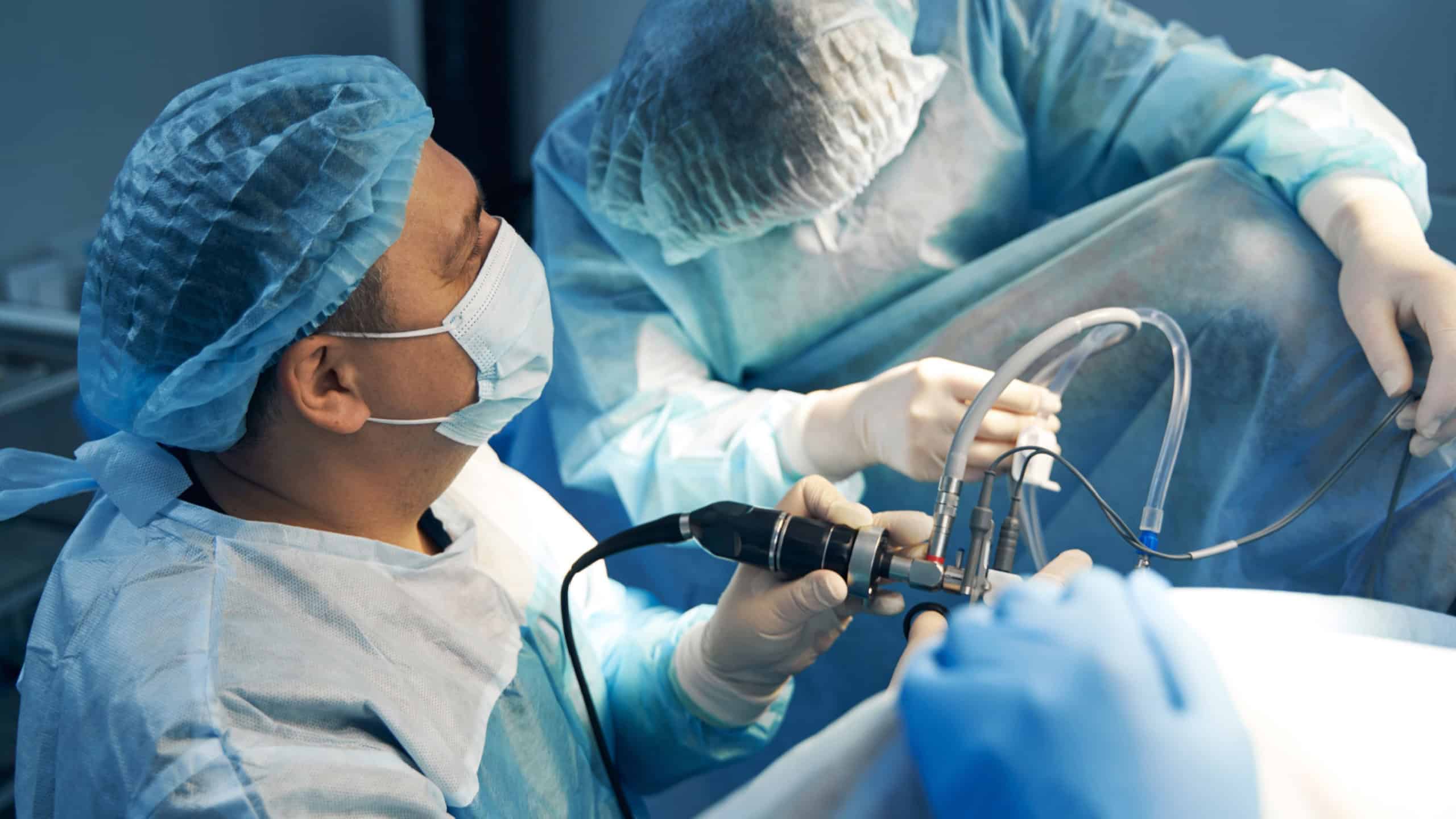 Laparoscopic instrument in hand of male surgeon during abdomen operation