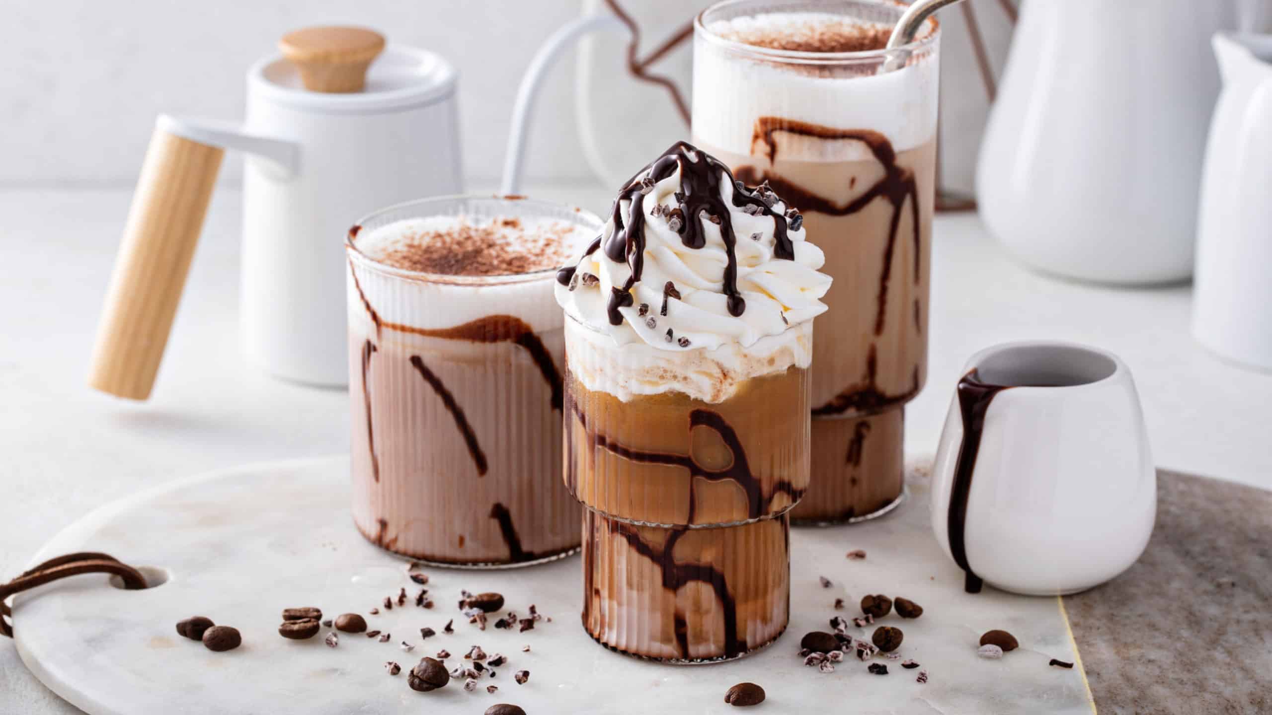 Mocha latte and iced frappe topped with whipped cream and chocolate syrup, refreshing and sweet coffee drinks