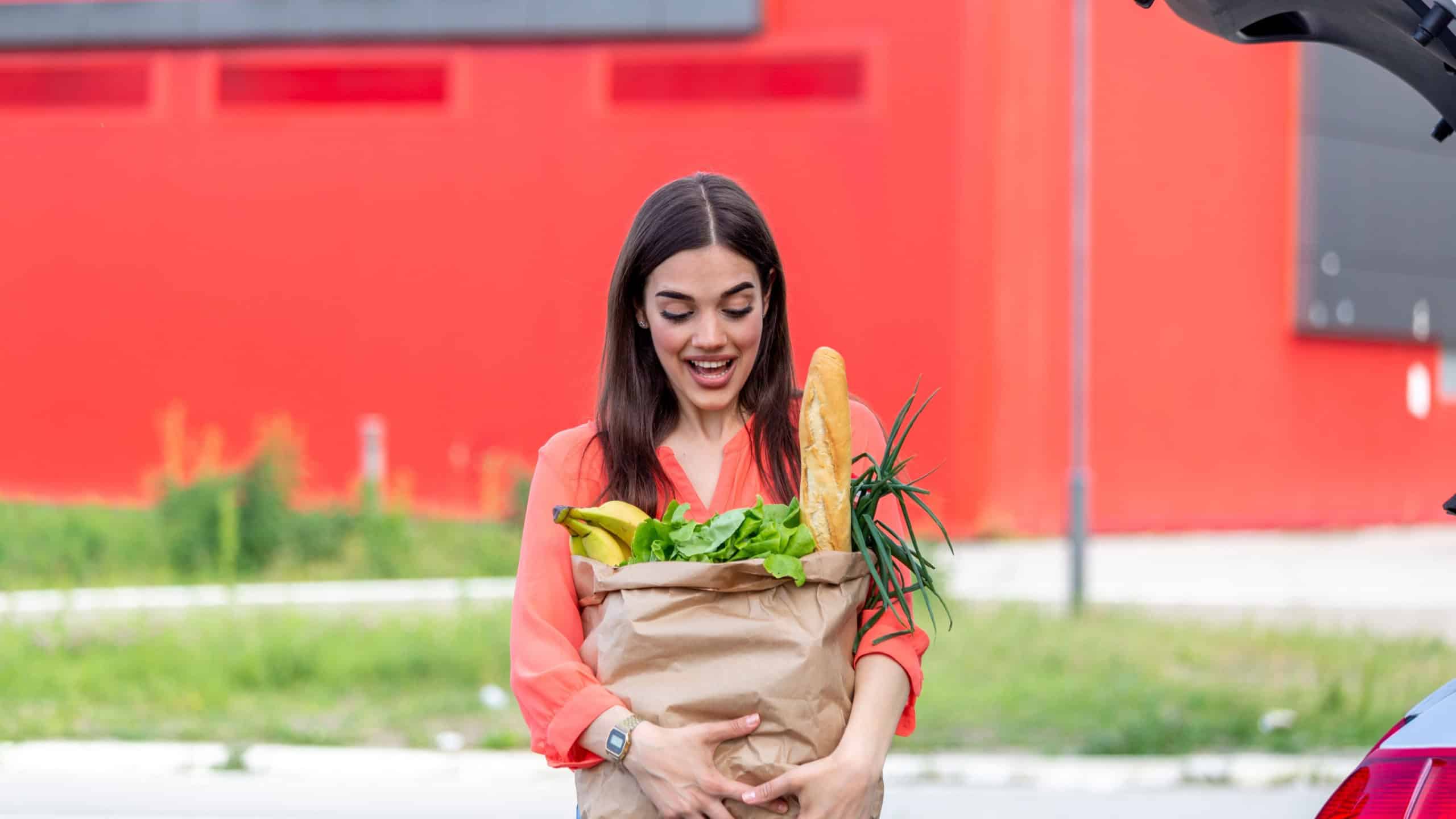 Woman after shopping in a mall or shopping canter and driving home now with her car outdoor.