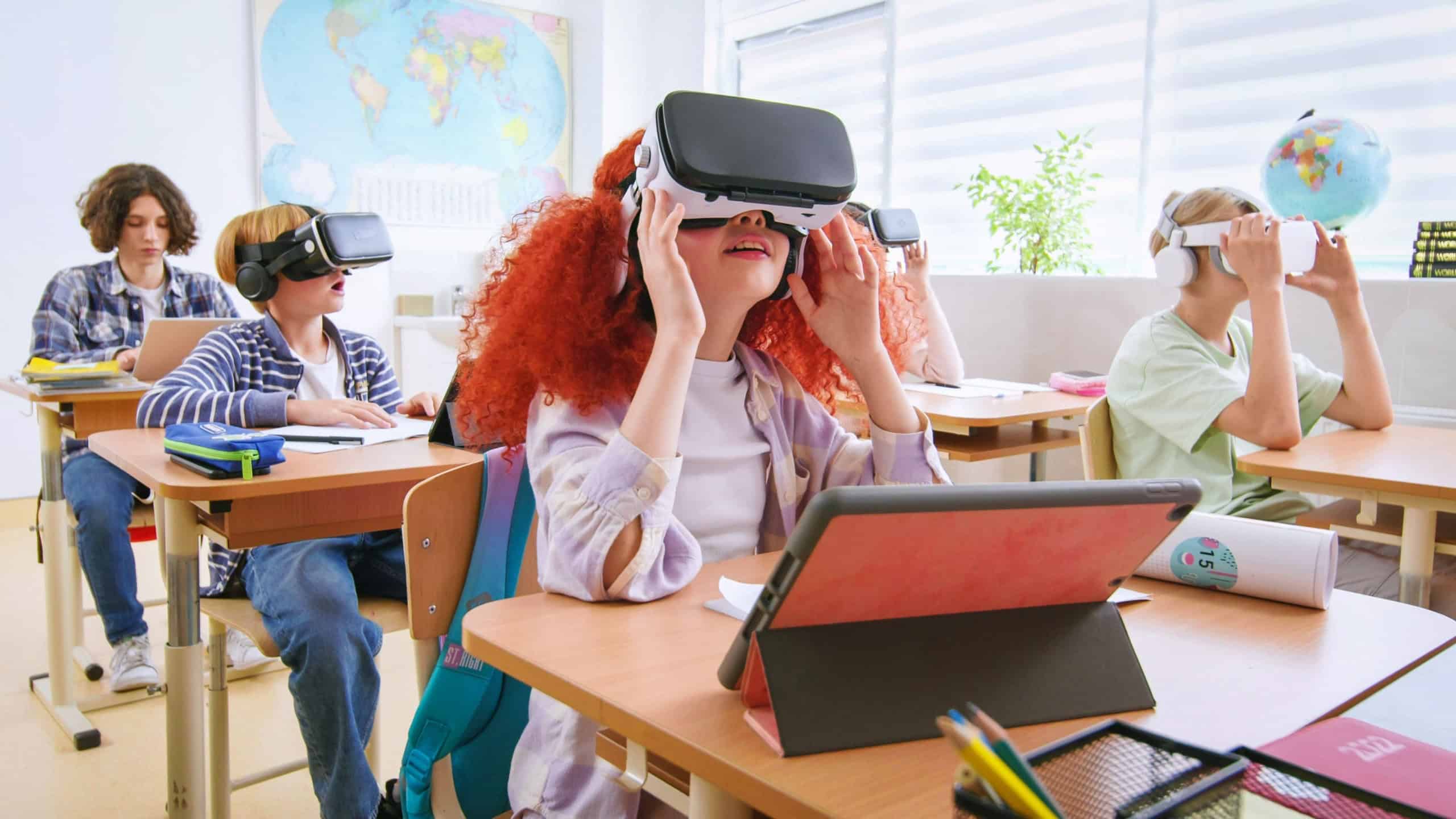 Interactive school concept. Kids in VR headsets sitting at desks and having virtual reality learning experience. Study technology. Kids in VR glasses in classroom. Tech education.