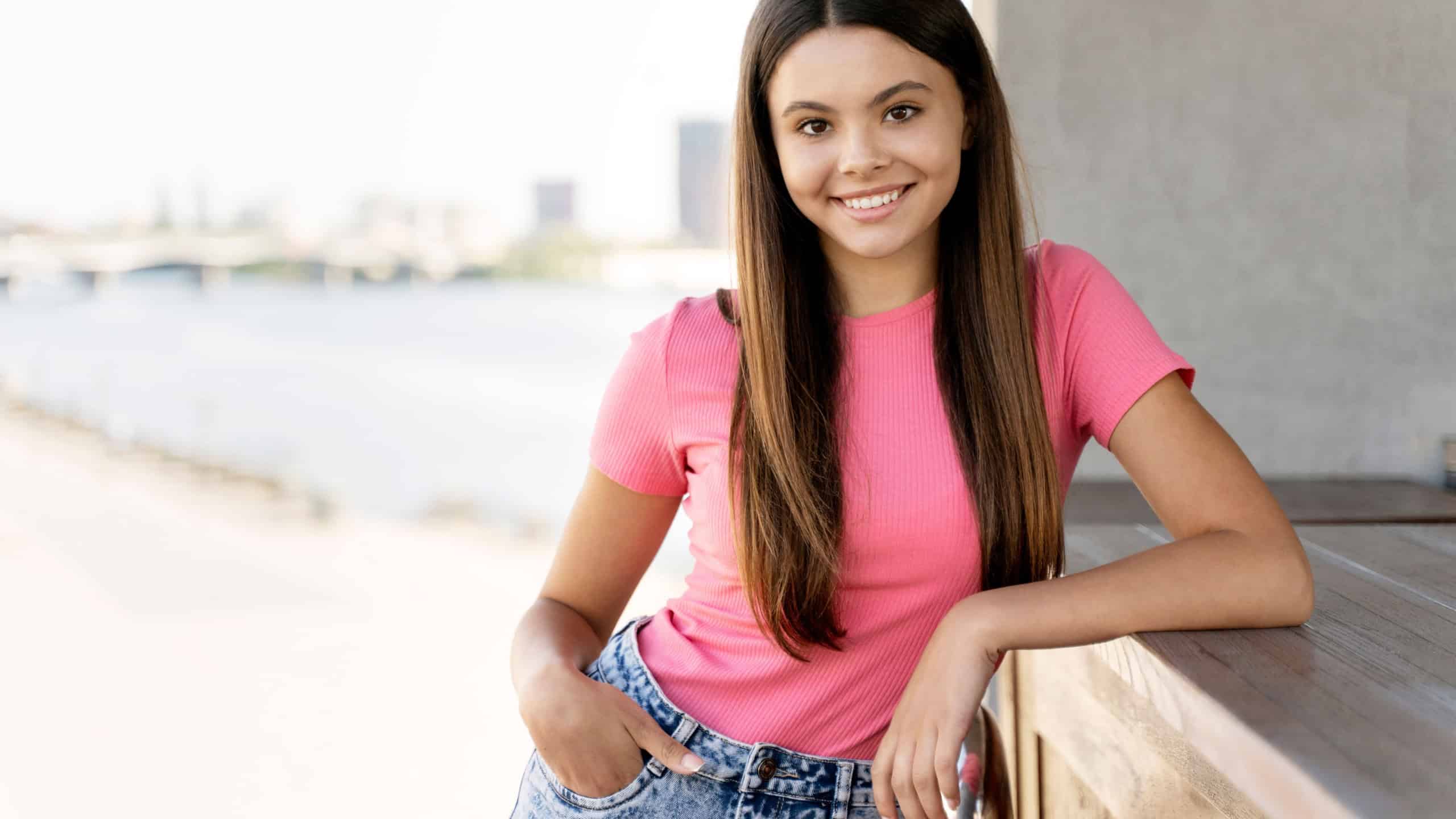 Authentic portrait of smiling teenage girl wearing stylish pink t-shirt