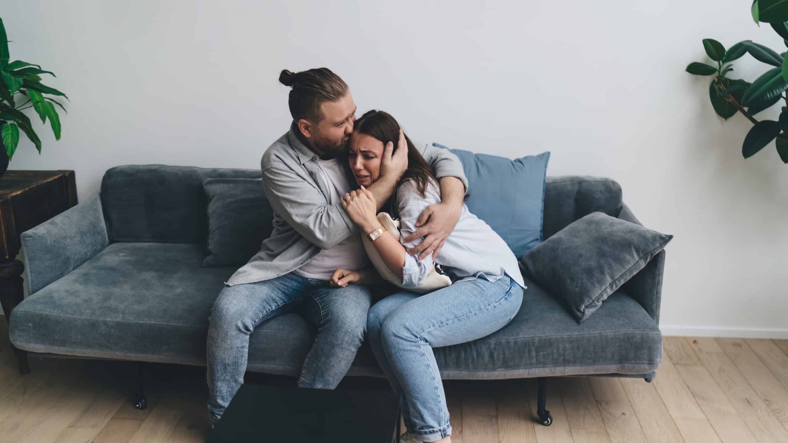 Loving man supporting unhappy young woman