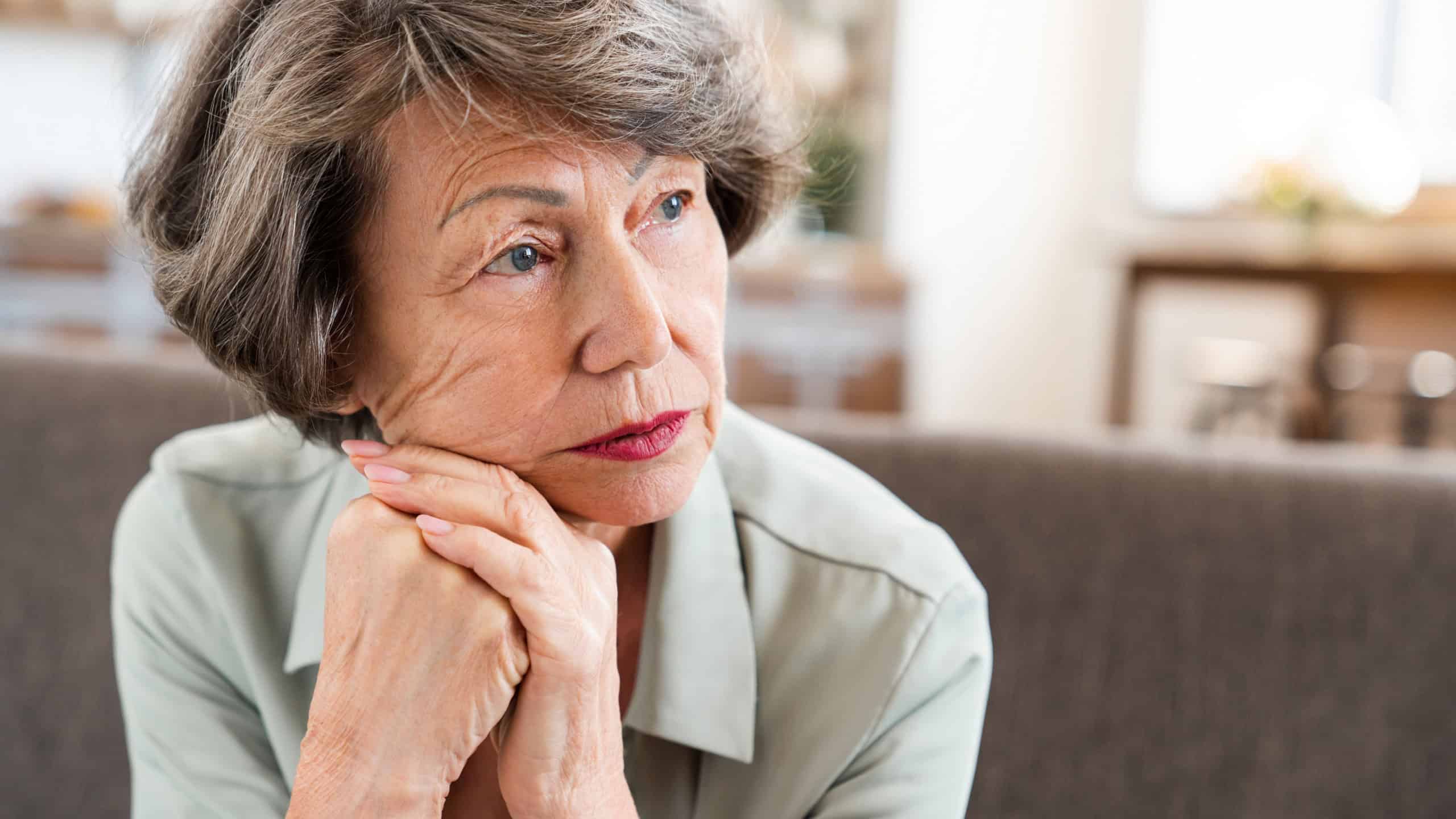Sad tired exhausted caucasian old woman thinking about future past having nostalgy grief. Grandmother suffering from pain depression loneliness at home