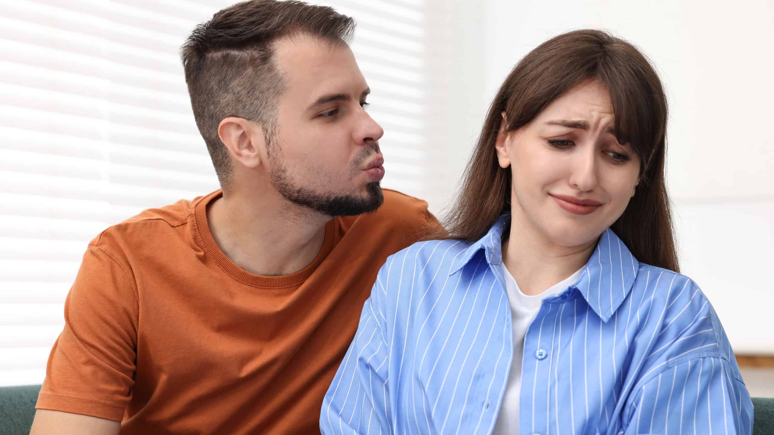 Man trying to kiss embarrassed woman at home