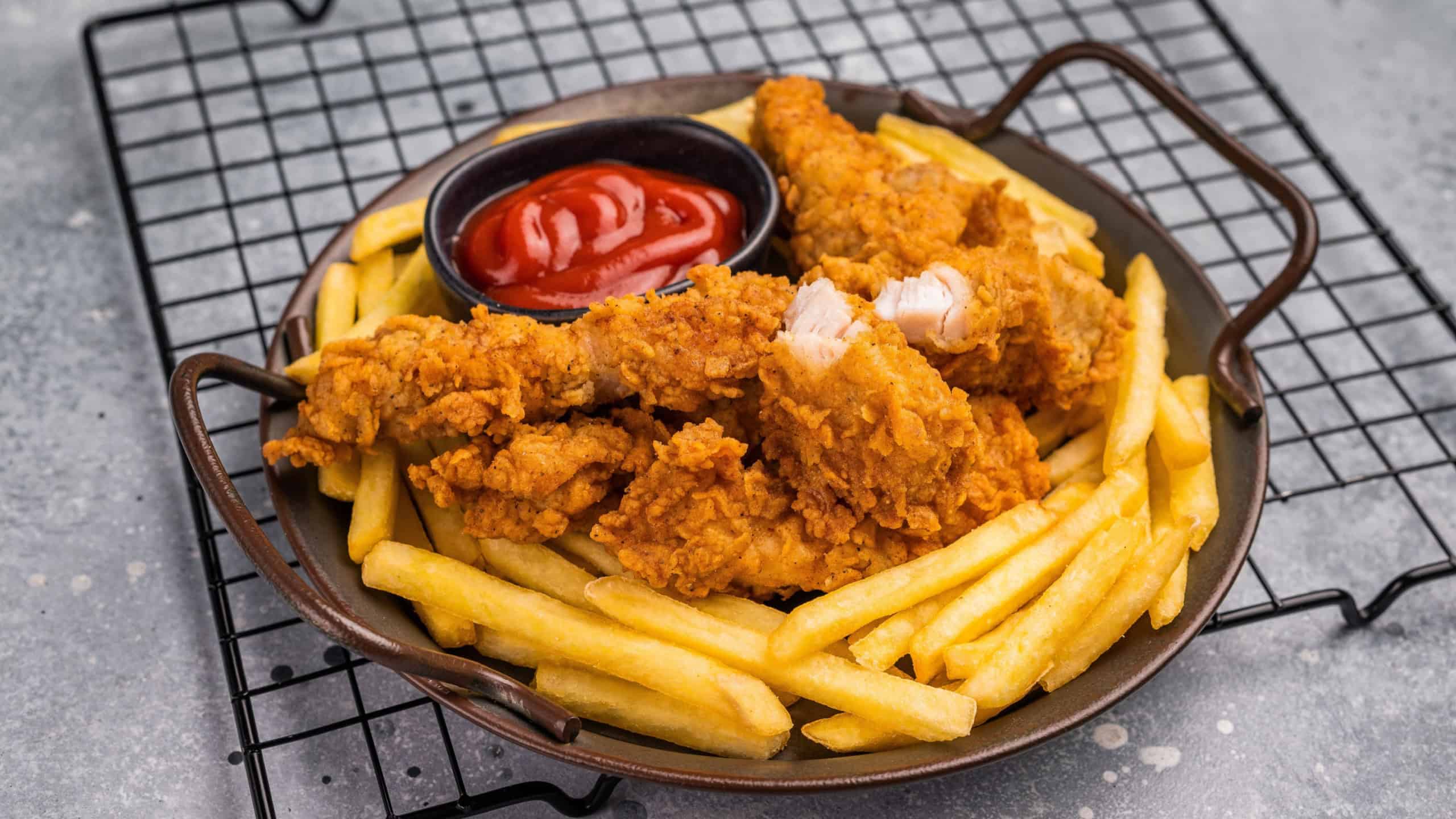 Deep fried chicken strips, stick from breast fillet. grey background. top view.