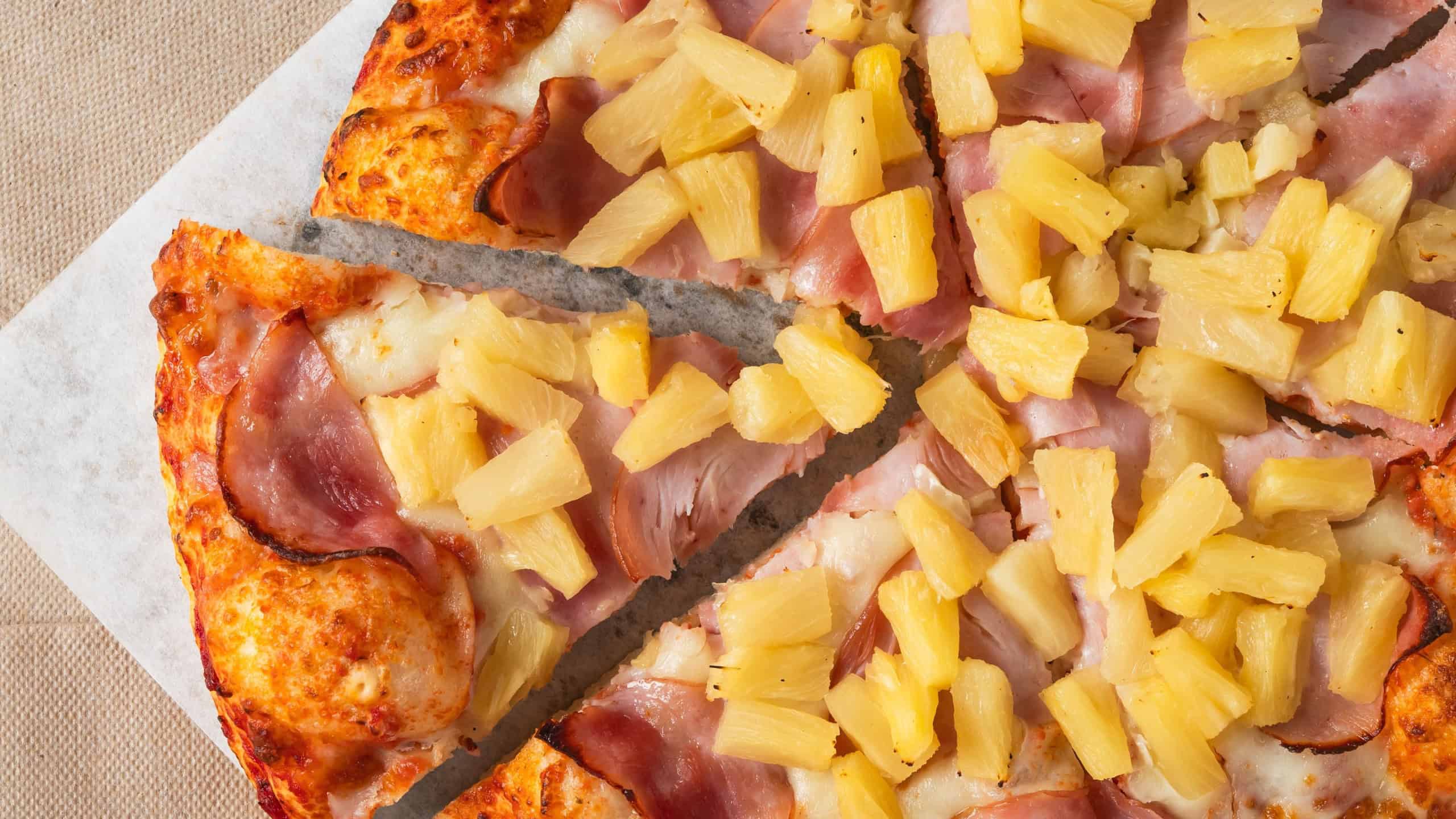 Classic Hawaiian pizza topped with sliced ham and chunks of sweet pineapple.