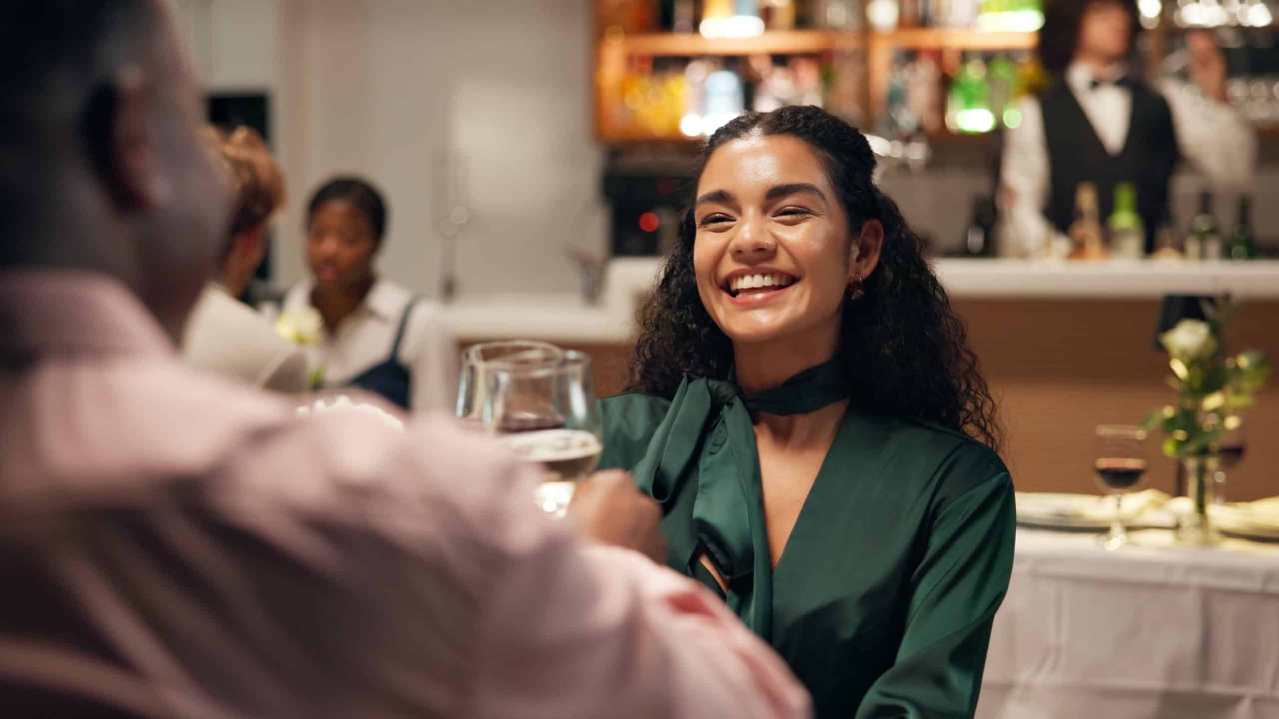 Couple, dating and toast in restaurant with wine for smile, romance or anniversary celebration. Hospitality, conversation and fine dining with man, woman and dinner with discussion and bonding