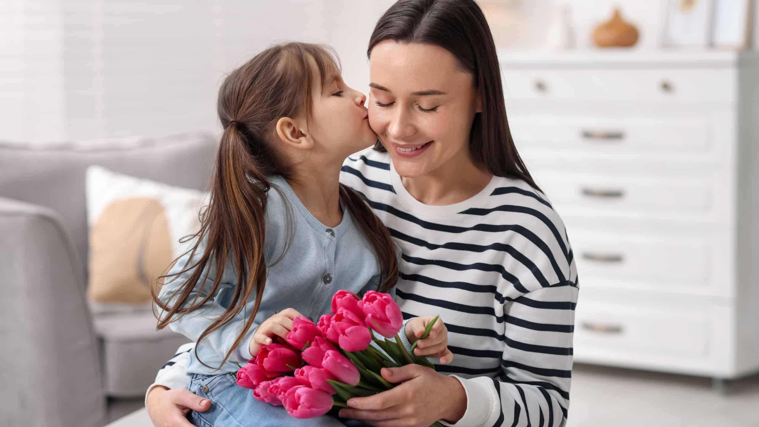 Happy Mother's Day. Little girl greeting her mom with beautiful flowers indoors