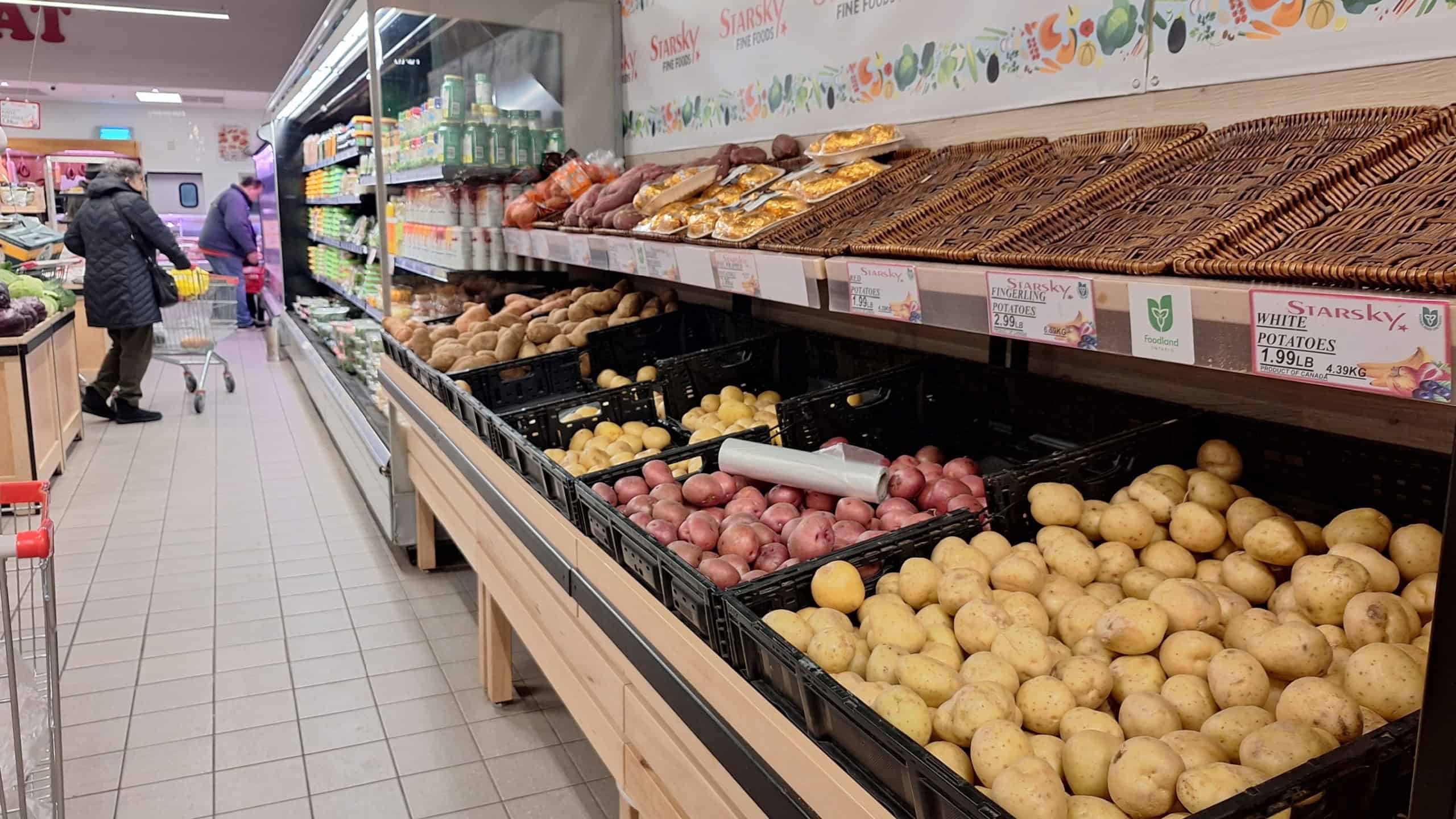 A shopper browses potato varieties at a grocery store