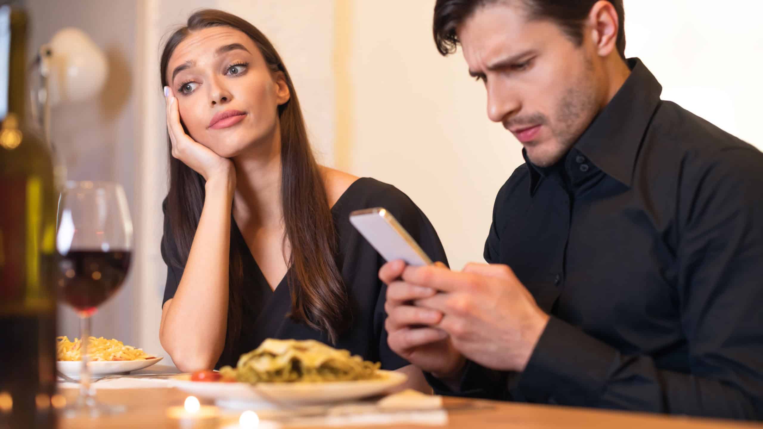 Unhappy Woman Bored On Date, Man Using Phone
