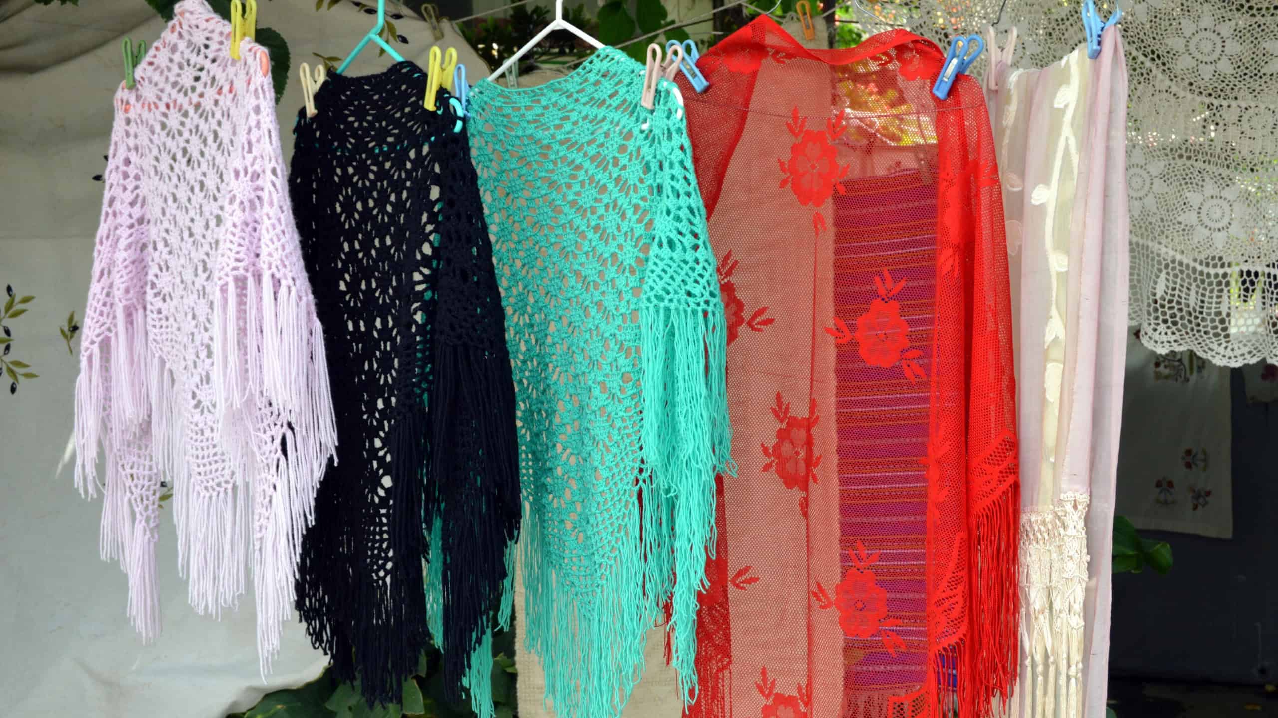 Shawls of several colors exaggerate in the hand.