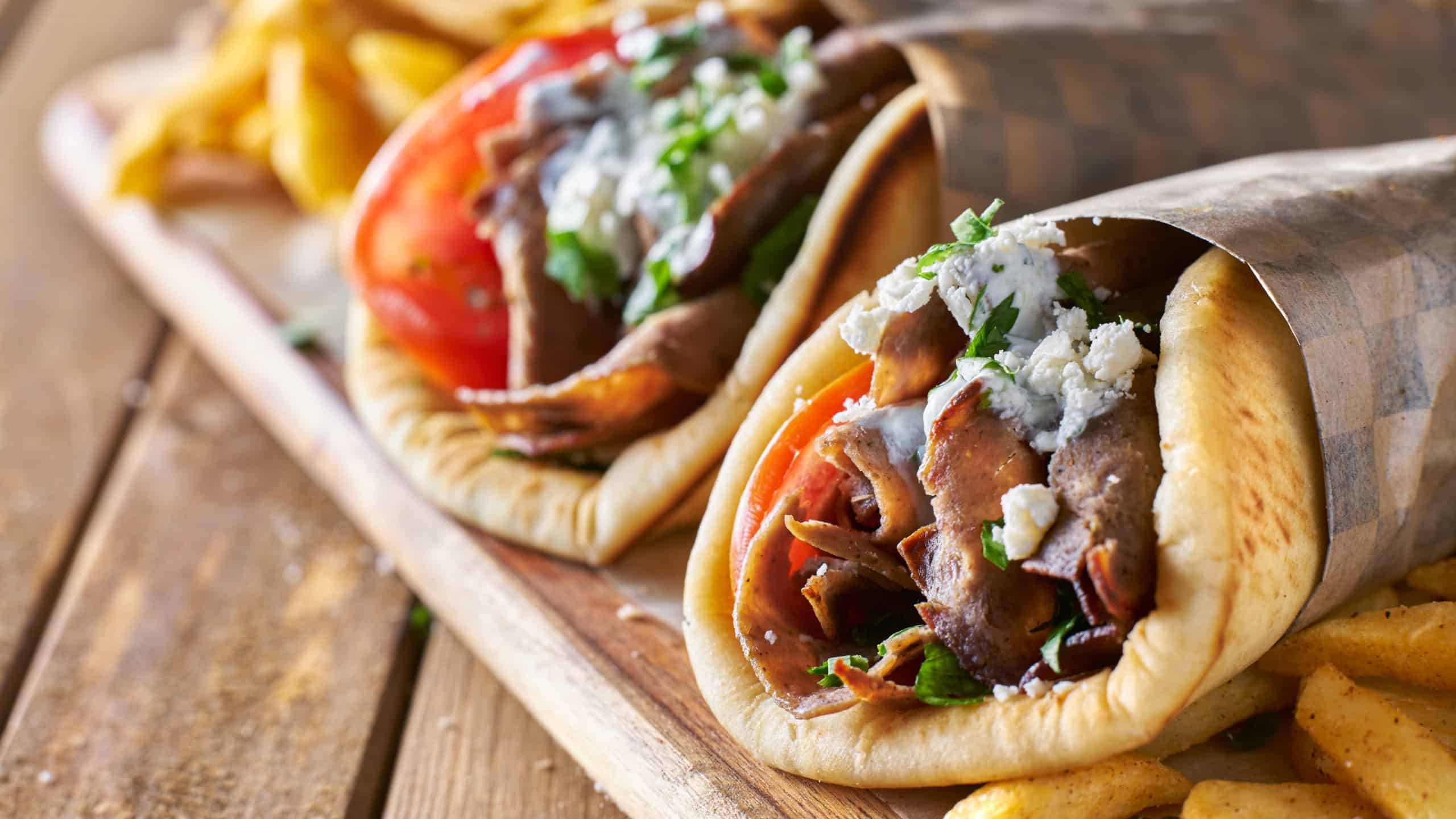 Two greek gyros with shaved lamb and french fries