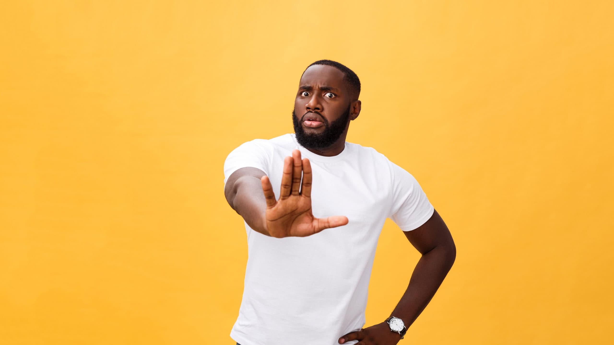 Portrait shock and annoyed displeased young man raising hands up to say no stop right there isolated orange background. Negative human emotion, facial expression, sign, symbol, body language