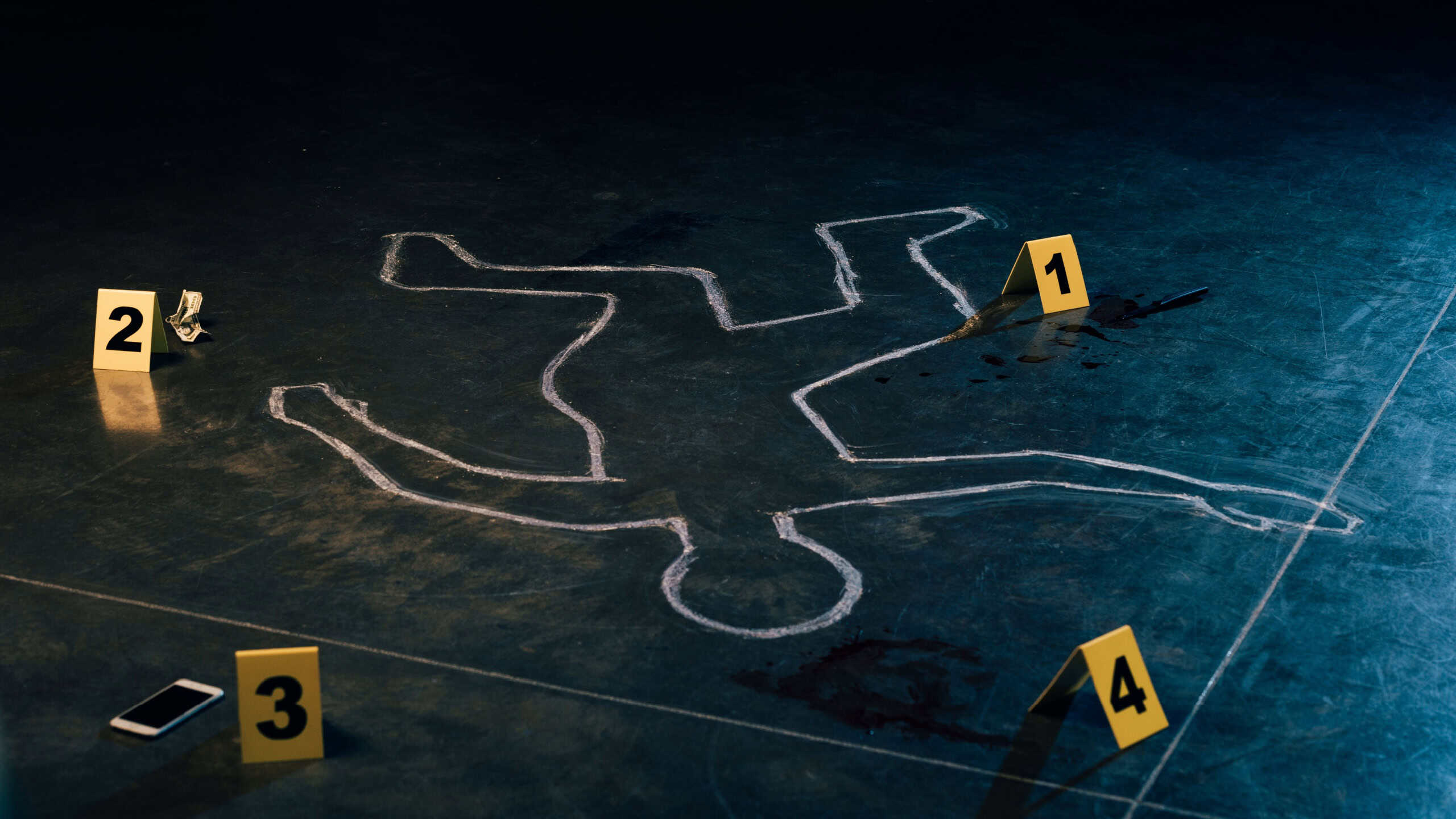 Chalk outline and evidence markers at crime scene