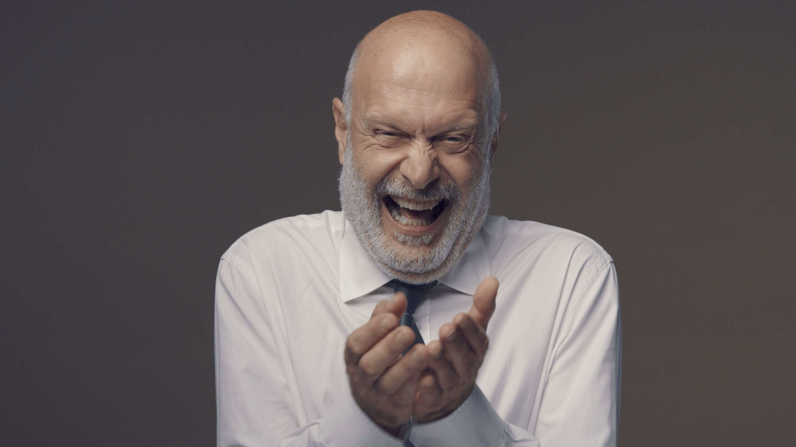 Cheerful middle-aged corporate businessman laughing out loud