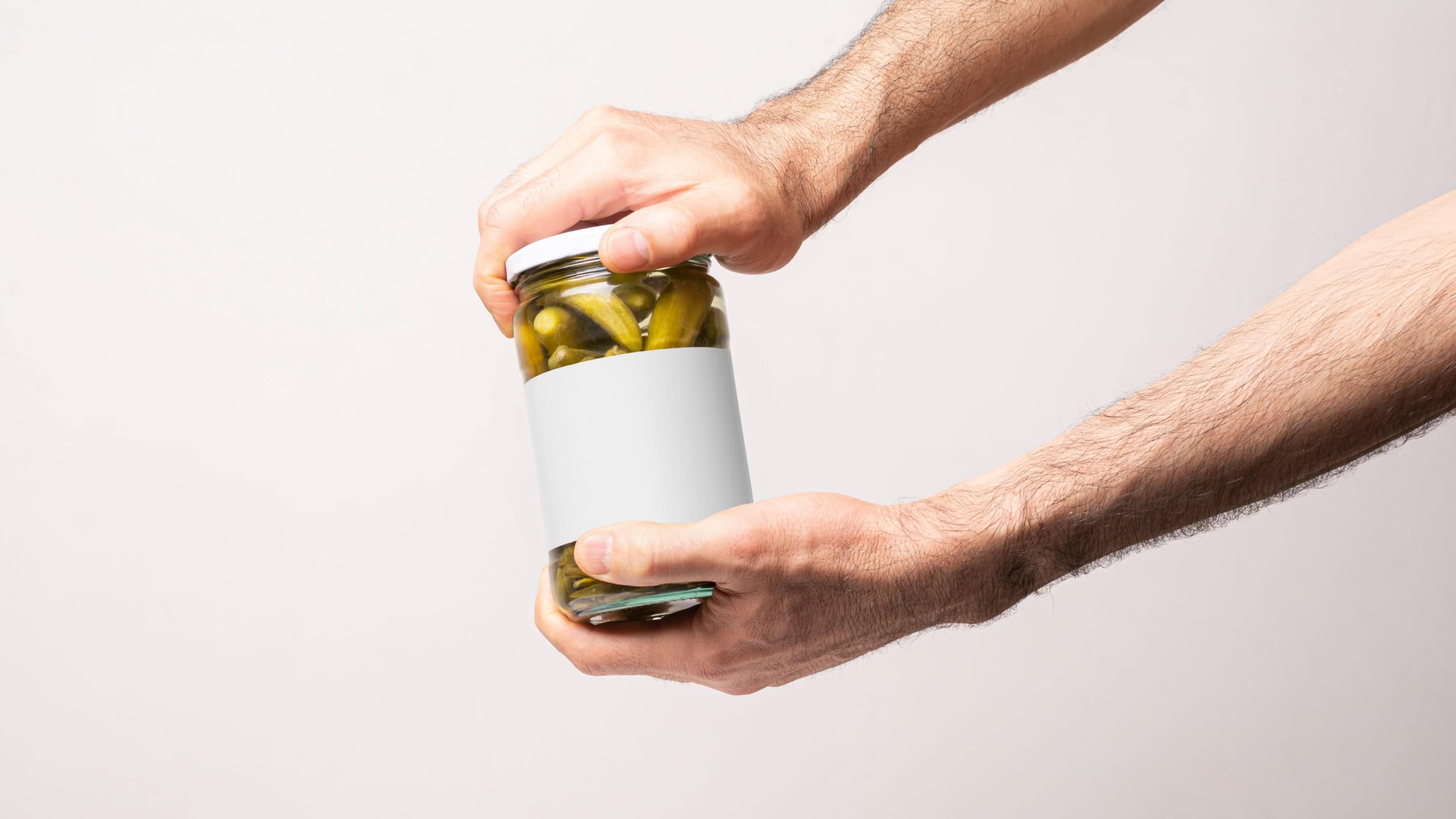Male hands opening a pickled cucumber jar lid, editable mock-up series template ready for your design, label selection path included.