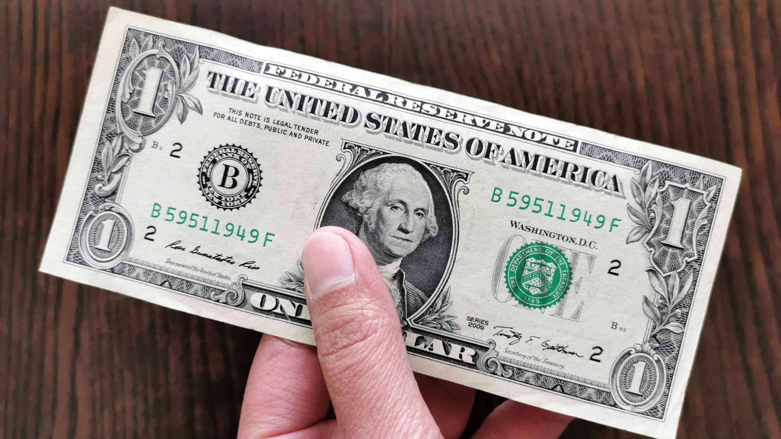 US one dollar bill in hand.