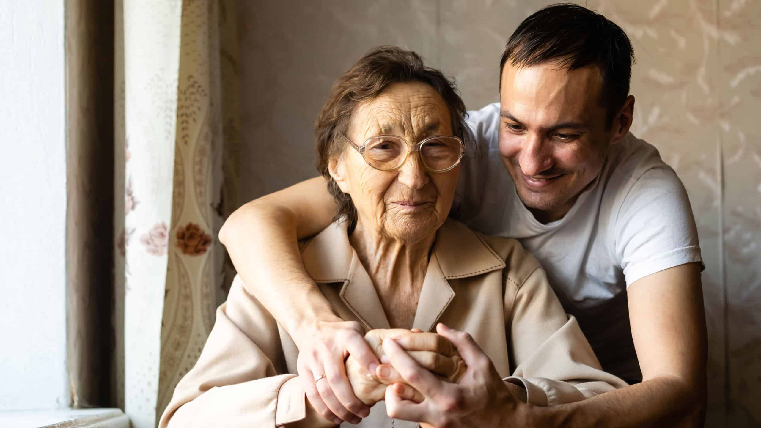 A very old woman and an adult grandson
