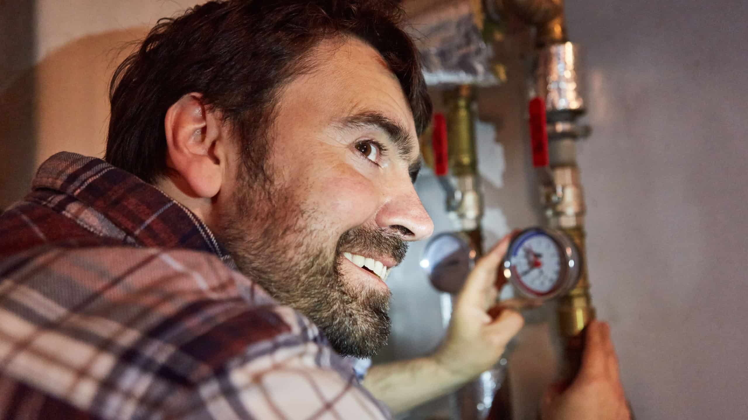 Do-it-yourselfer or plumber checks the water pressure of the heating installation in the basement