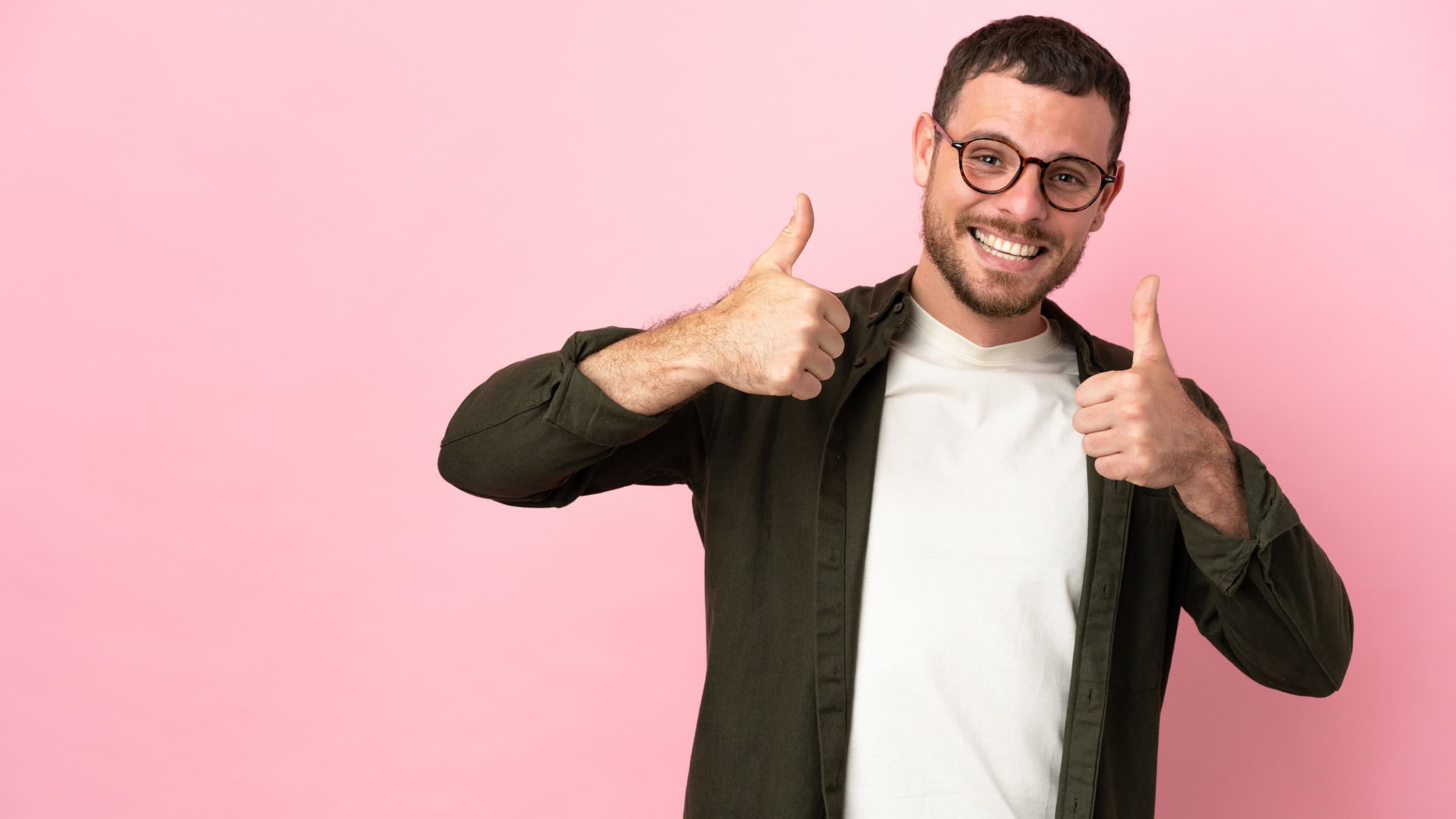 Young Brazilian man isolated on pink background giving a thumbs up gesture