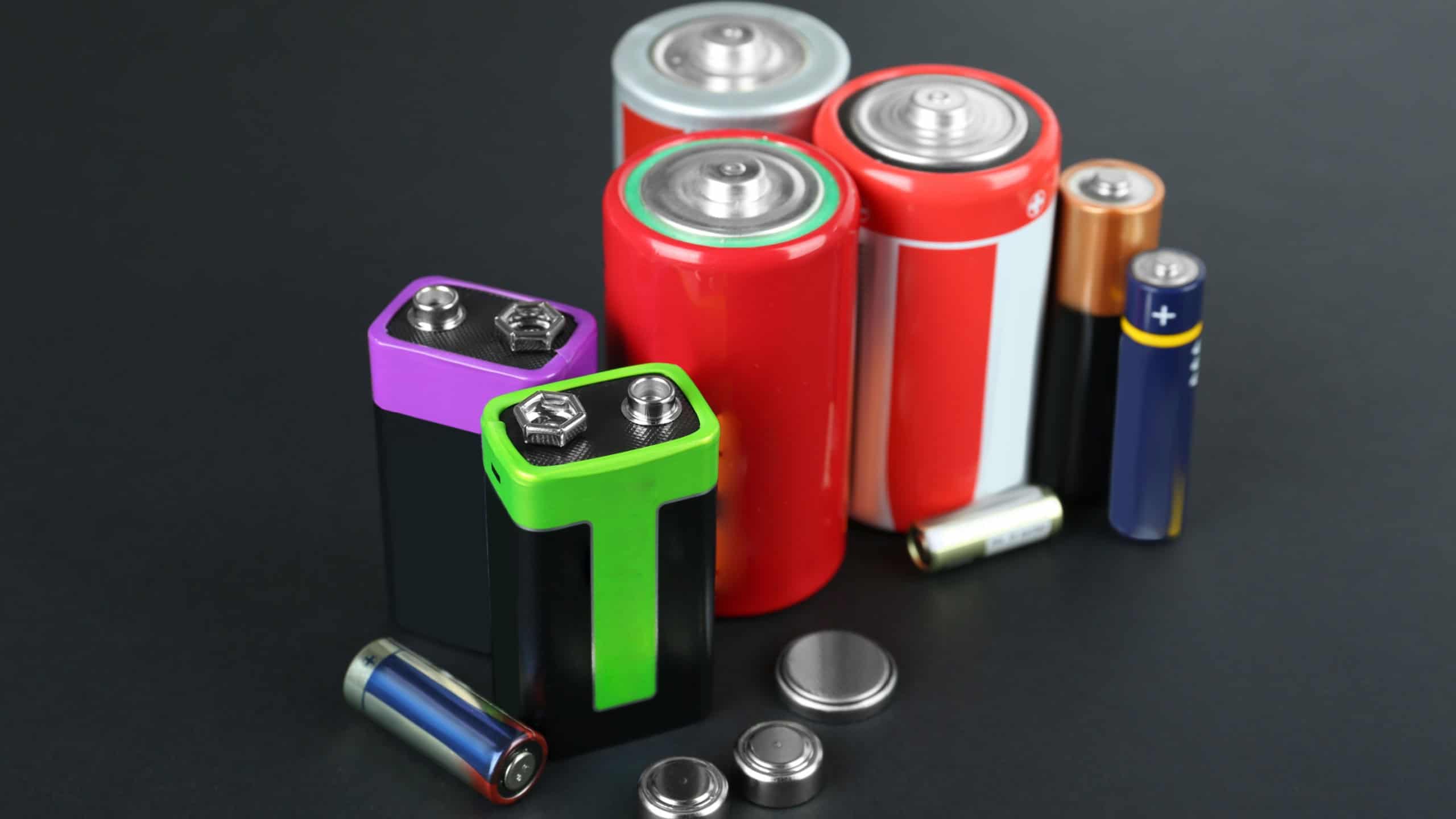 Different types of batteries on black background