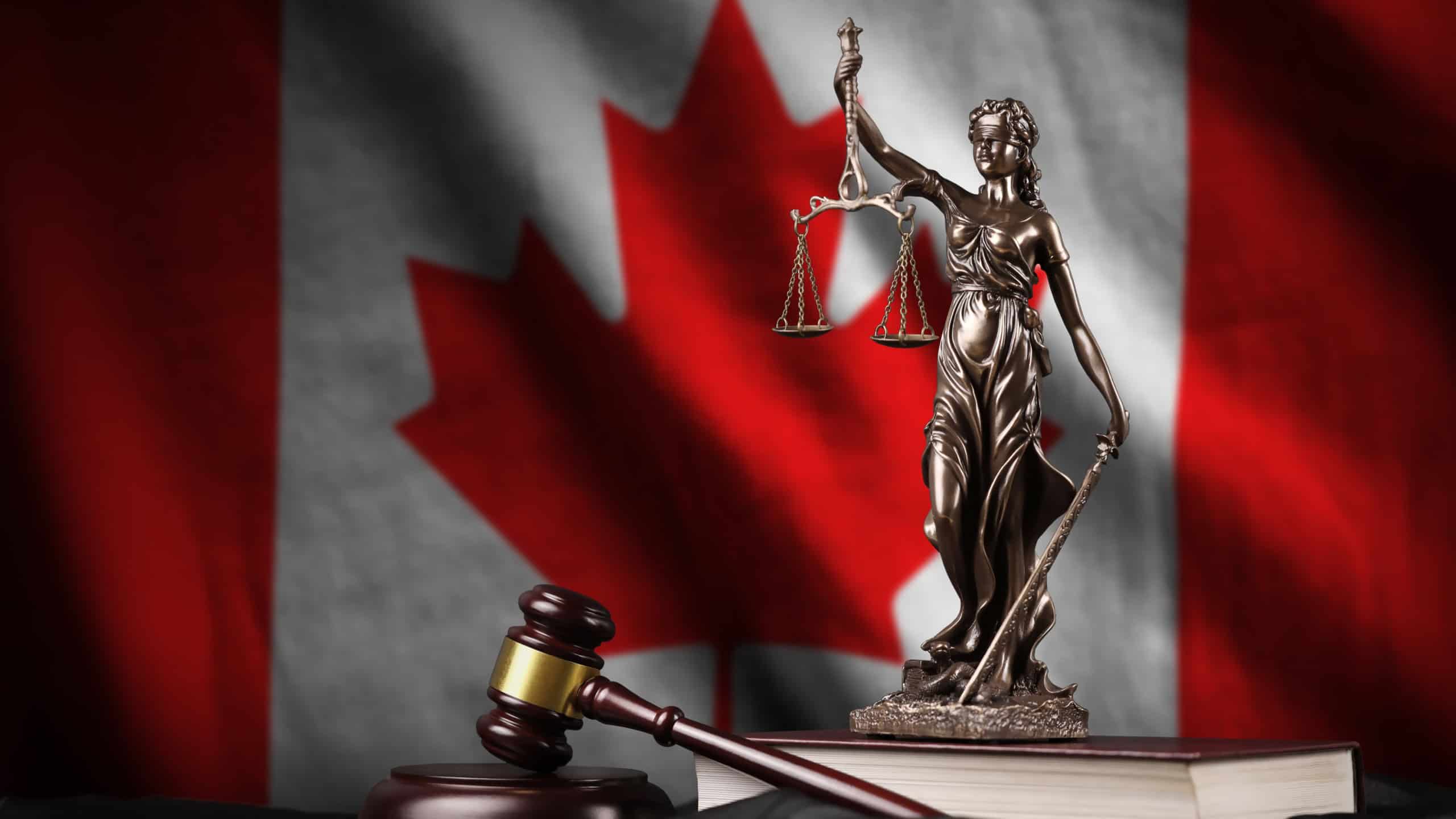 Canada flag with statue of lady justice, constitution and judge hammer on black drapery. Concept of judgement and punishment