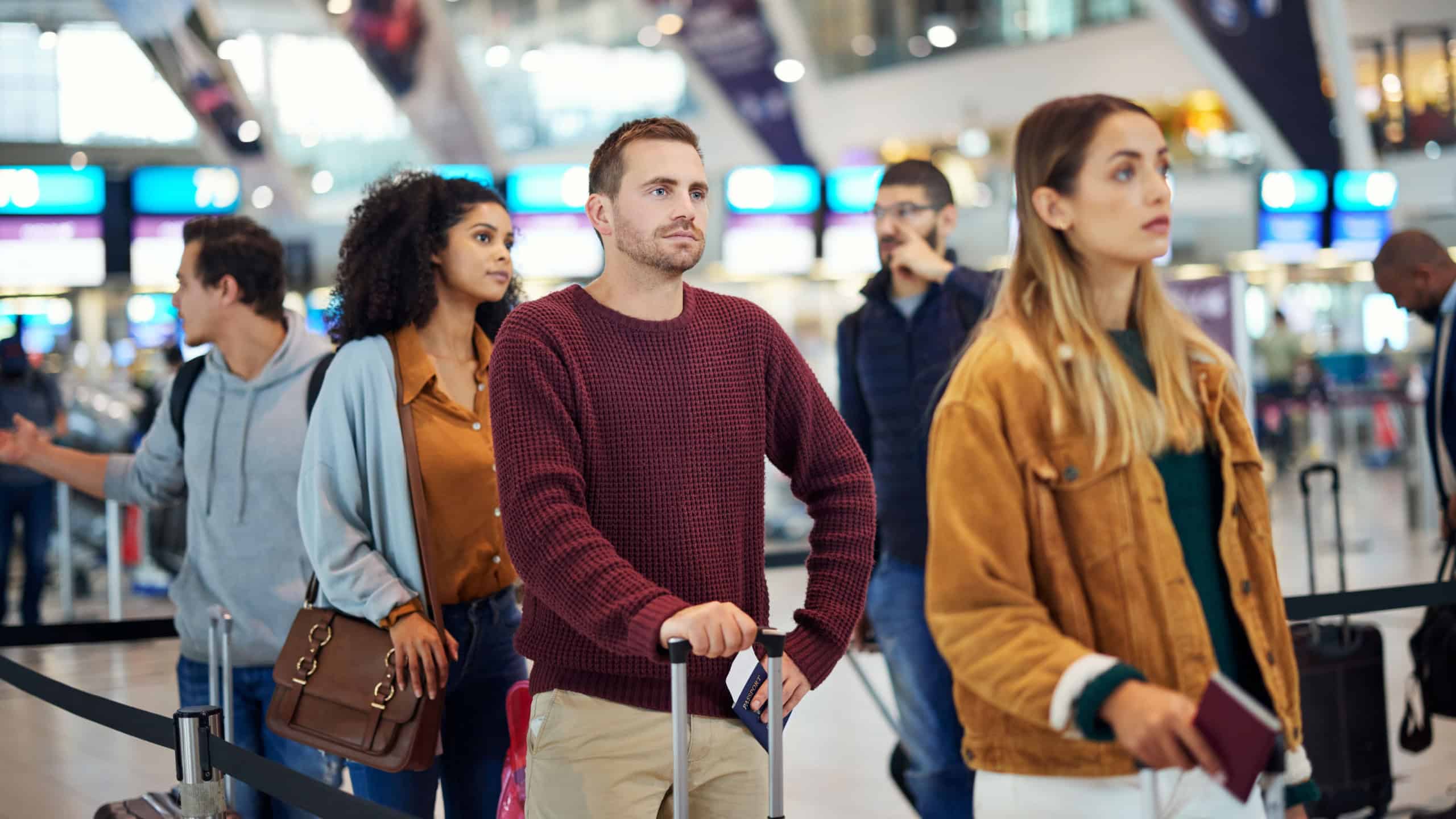 Travel, queue and wait with man in airport for vacation, international trip and tourism. Holiday, luggage and customs with passenger in line for airline ticket, departure and flight transportation