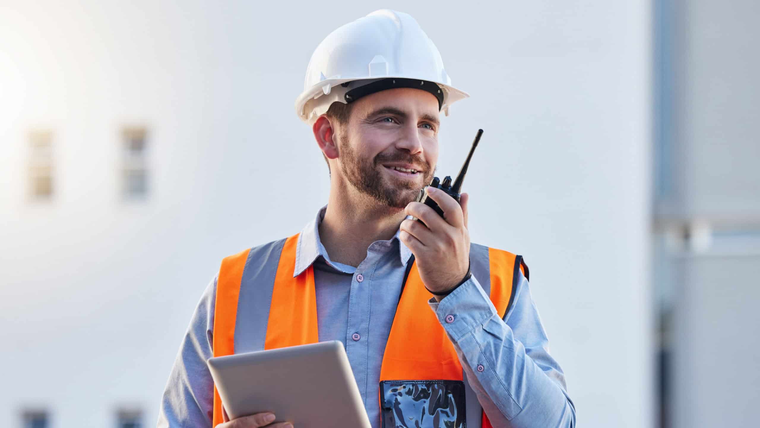 Walkie talkie of construction worker man for project management, planning or communication on tablet workflow. Architecture, contractor or happy engineering person with 5g tech for industrial update