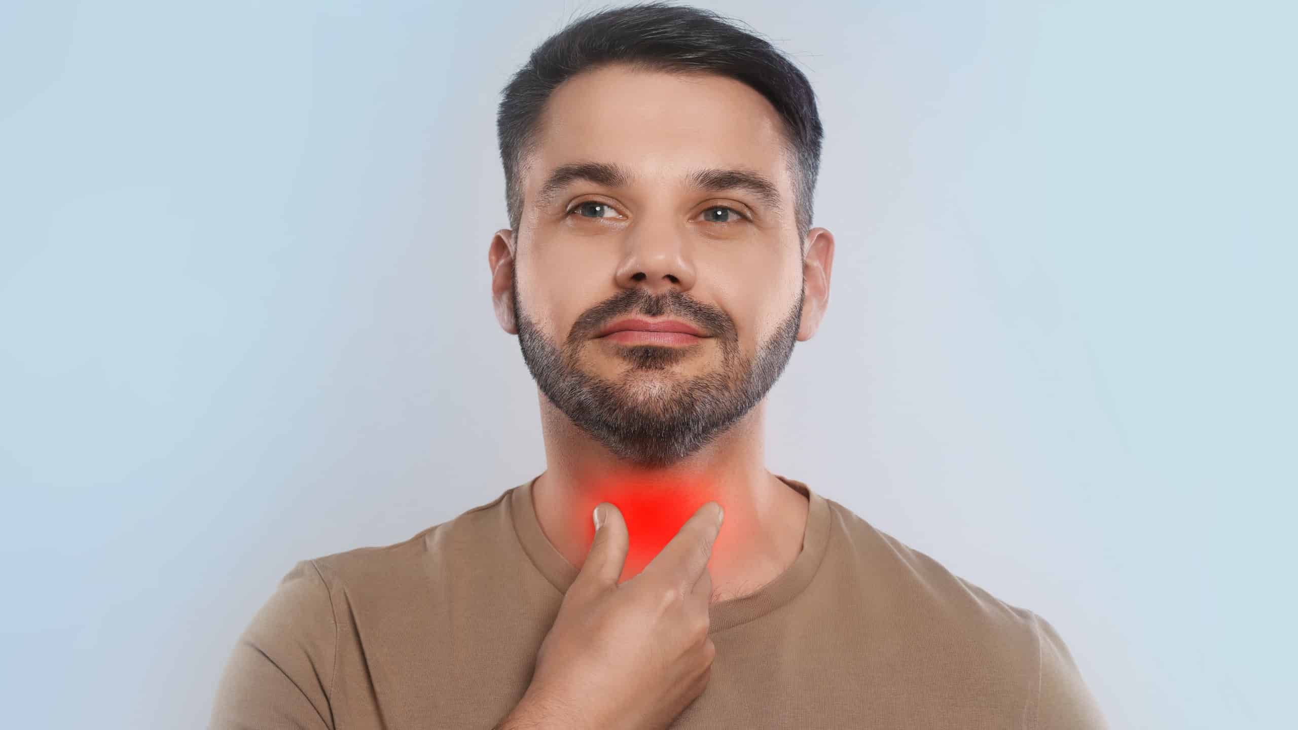 Endocrine system. Man doing thyroid self examination on light grey background