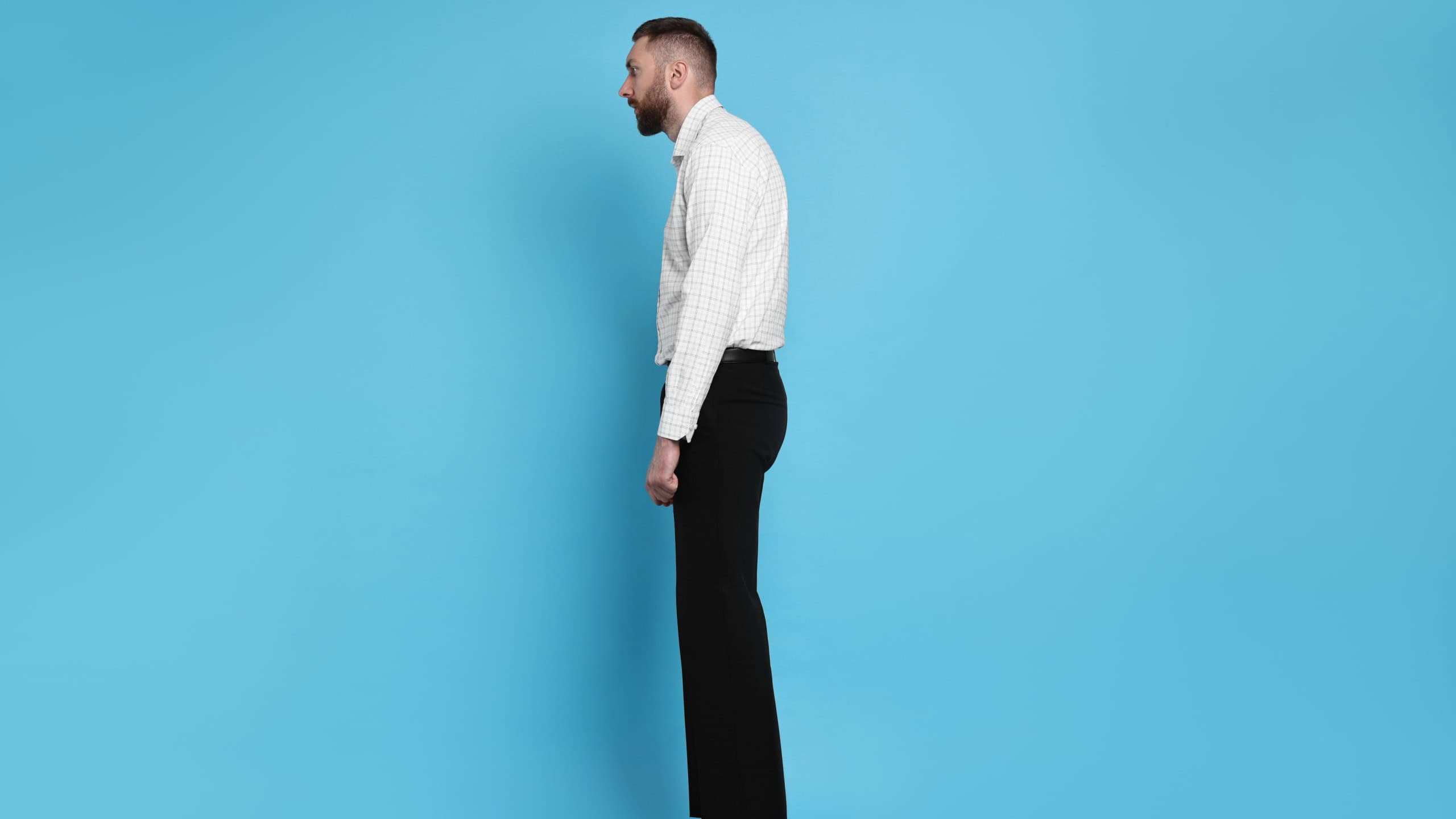 Man with poor posture on light blue background
