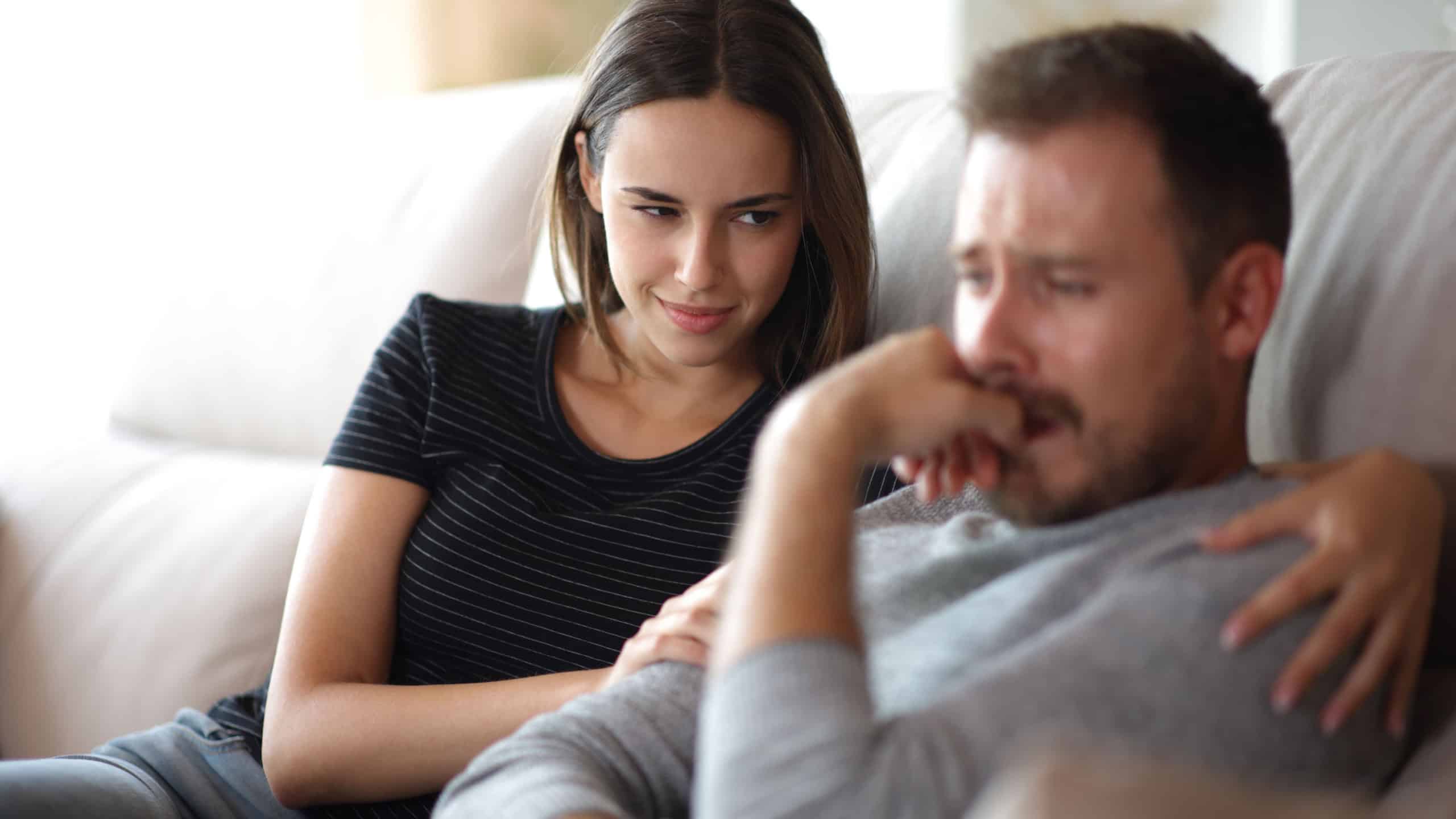 False bad friend happy to see her sad mate on a couch at home