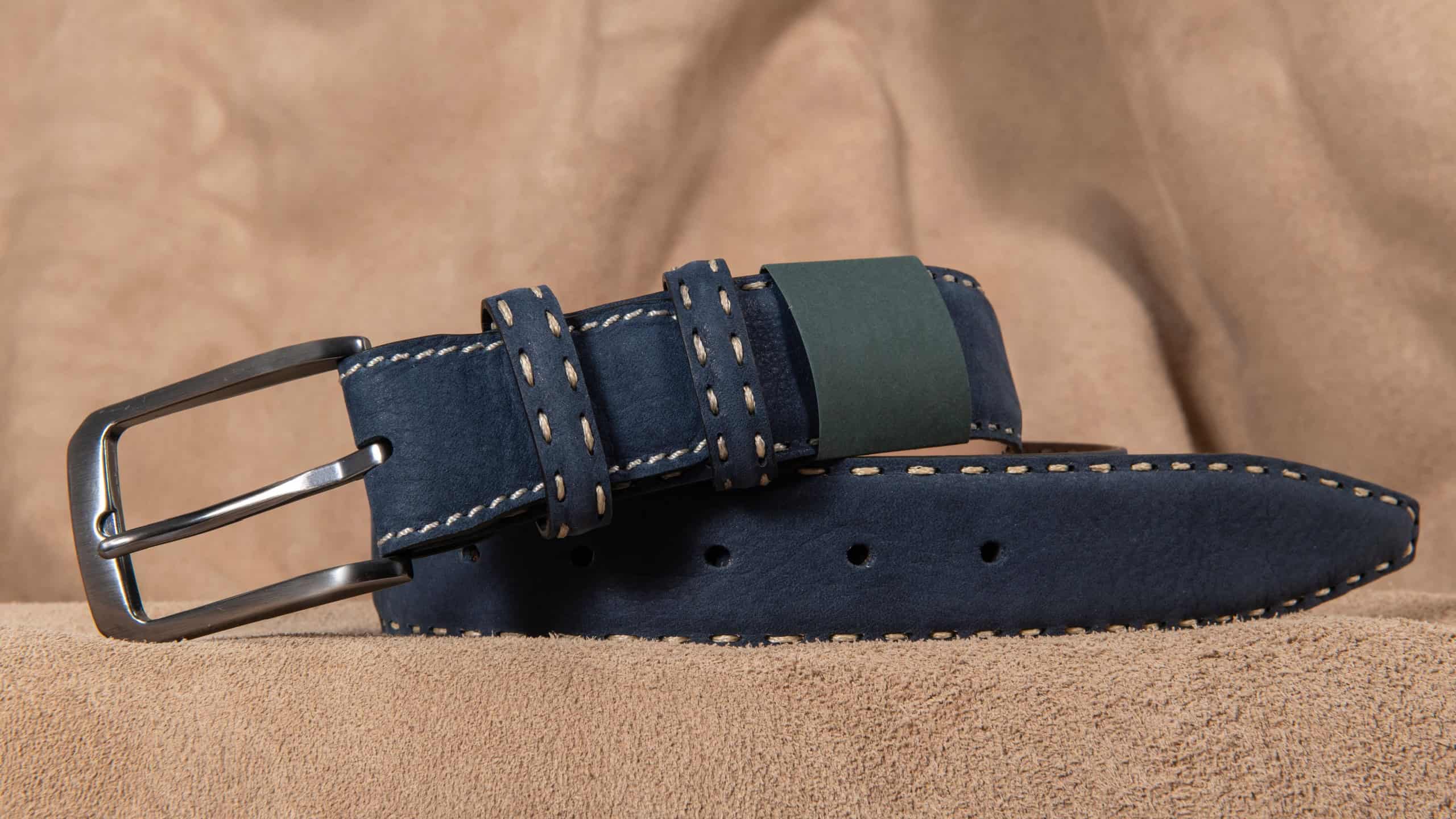 Navy blue colored leather belt. Navy blue colored leather belt on a leather background.