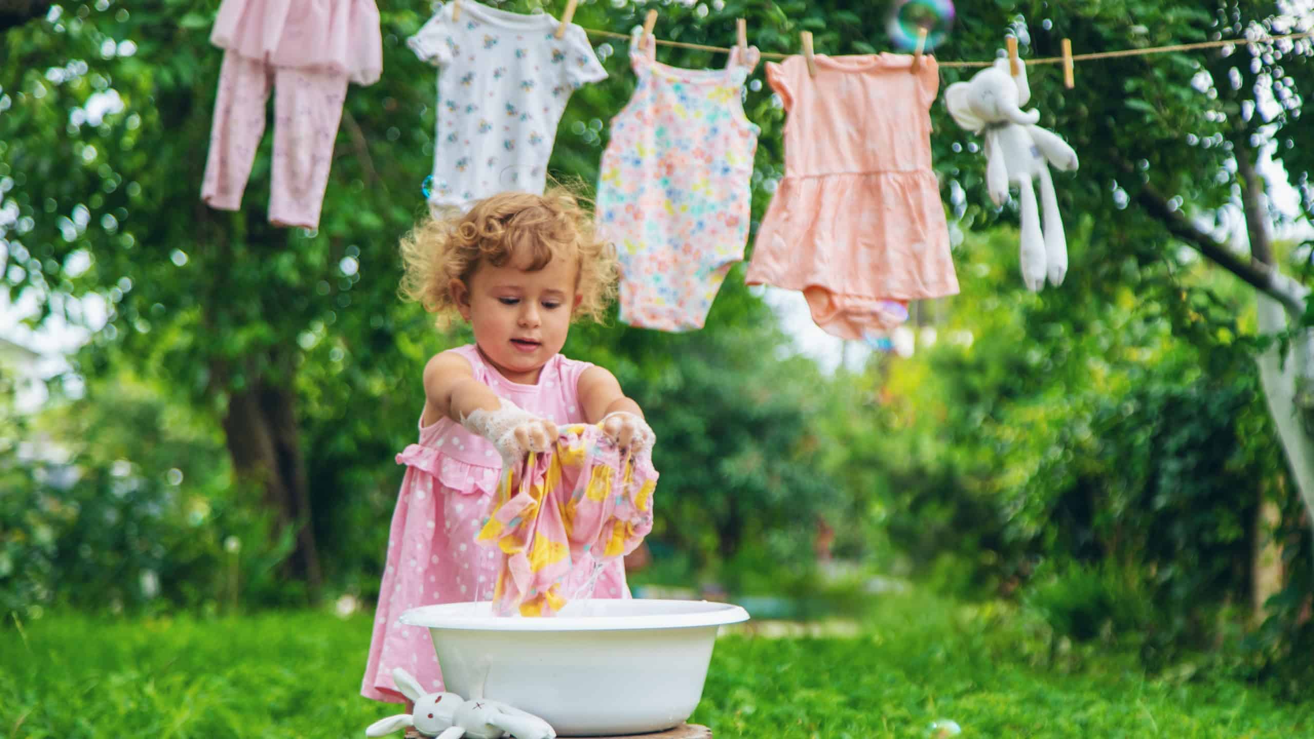 The child washes clothes and toys. Selective focus. Kid.