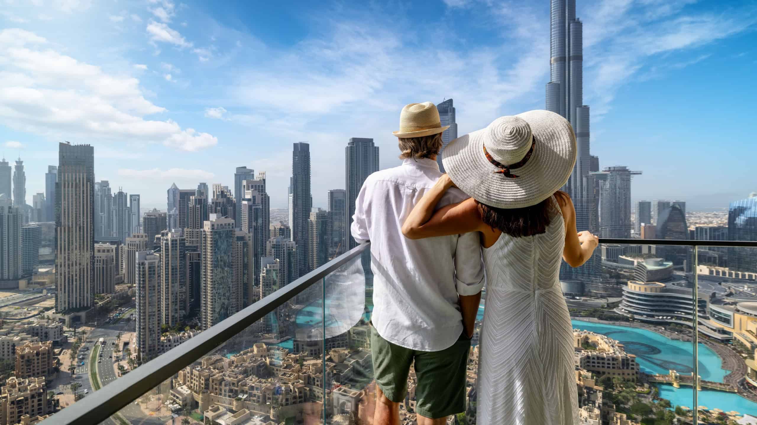 A hugging tourist couple enjoys the panoramic view of the skyline of Downtown Dubai, UAE