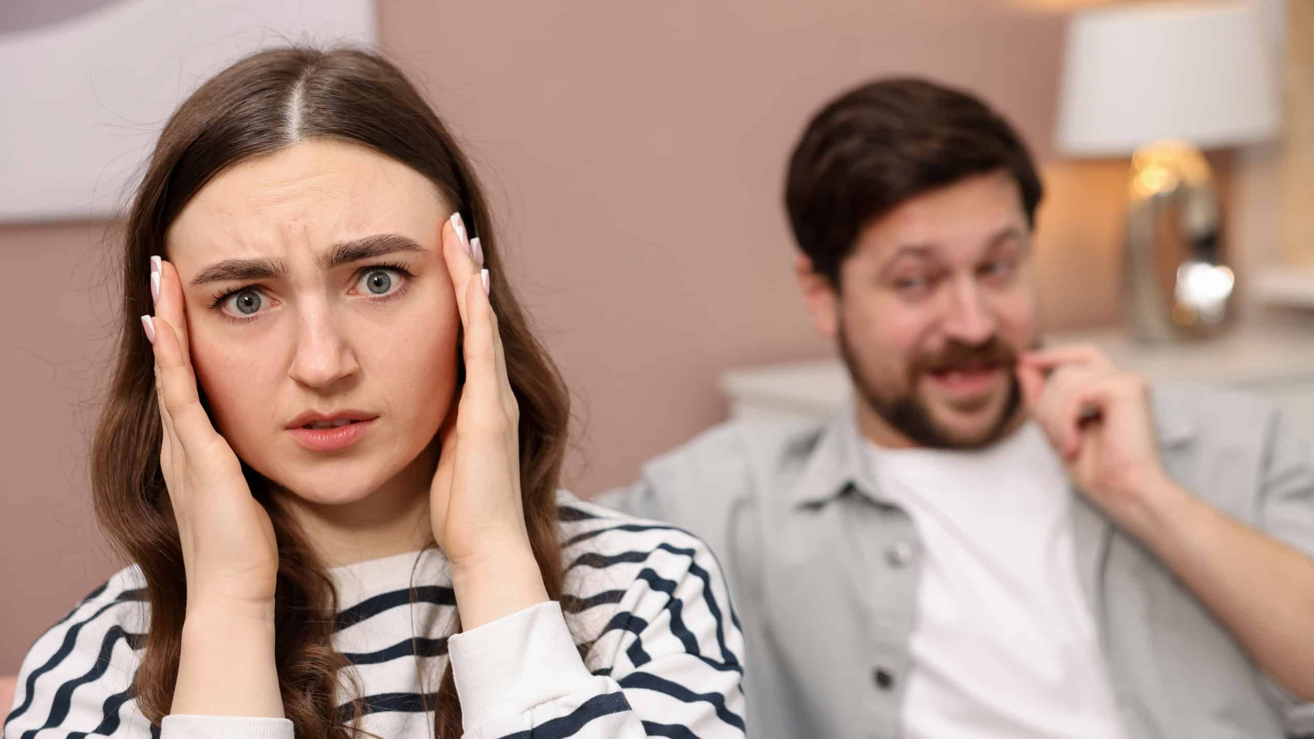 Embarrassed woman ignoring flirting man at home, selective focus