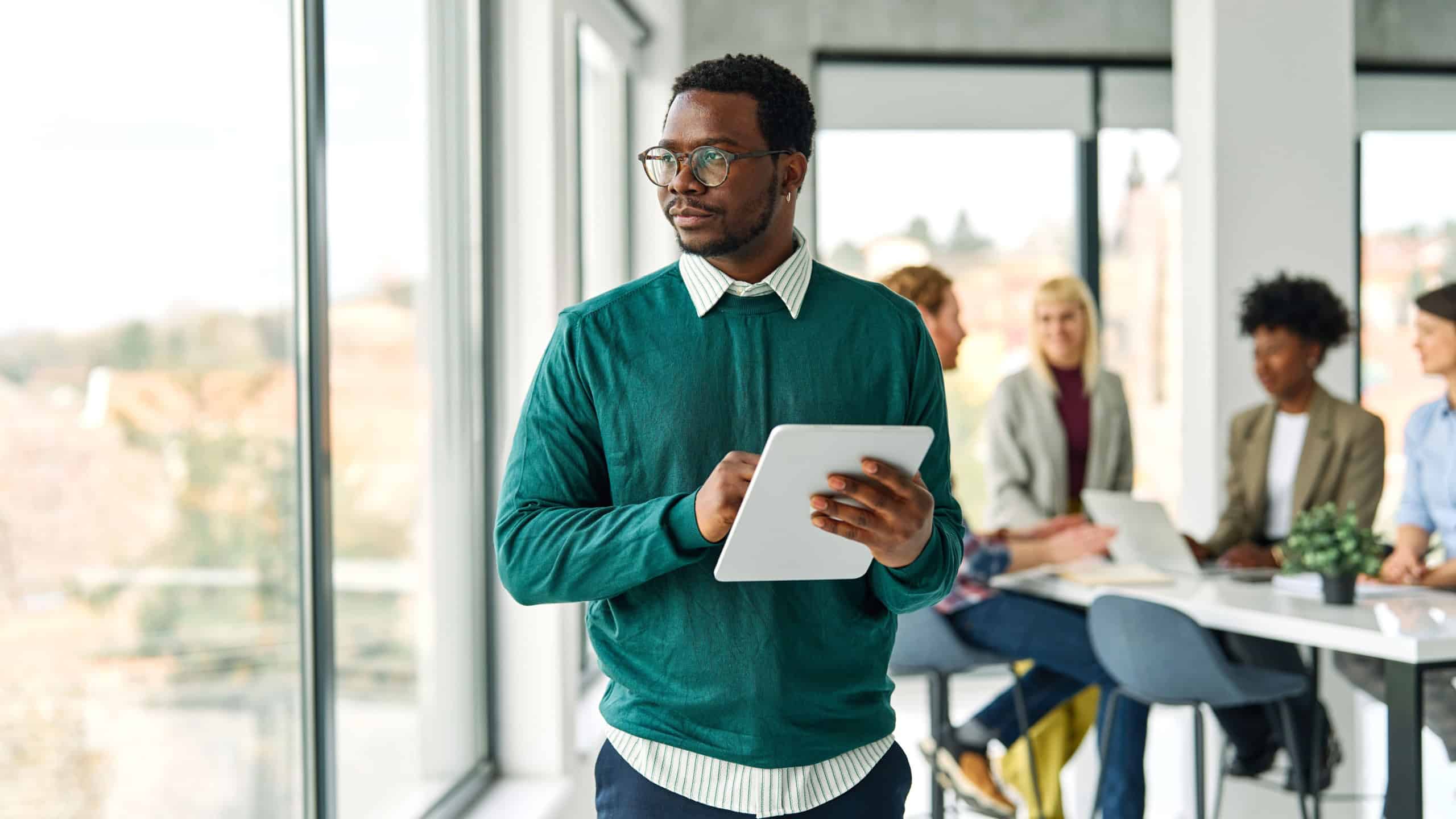 Portrait of a group of young business people having a meeting or training in the office. Teamwork and success concept, portrait of a smart young businessman, student, teacher or coach holding a tablet