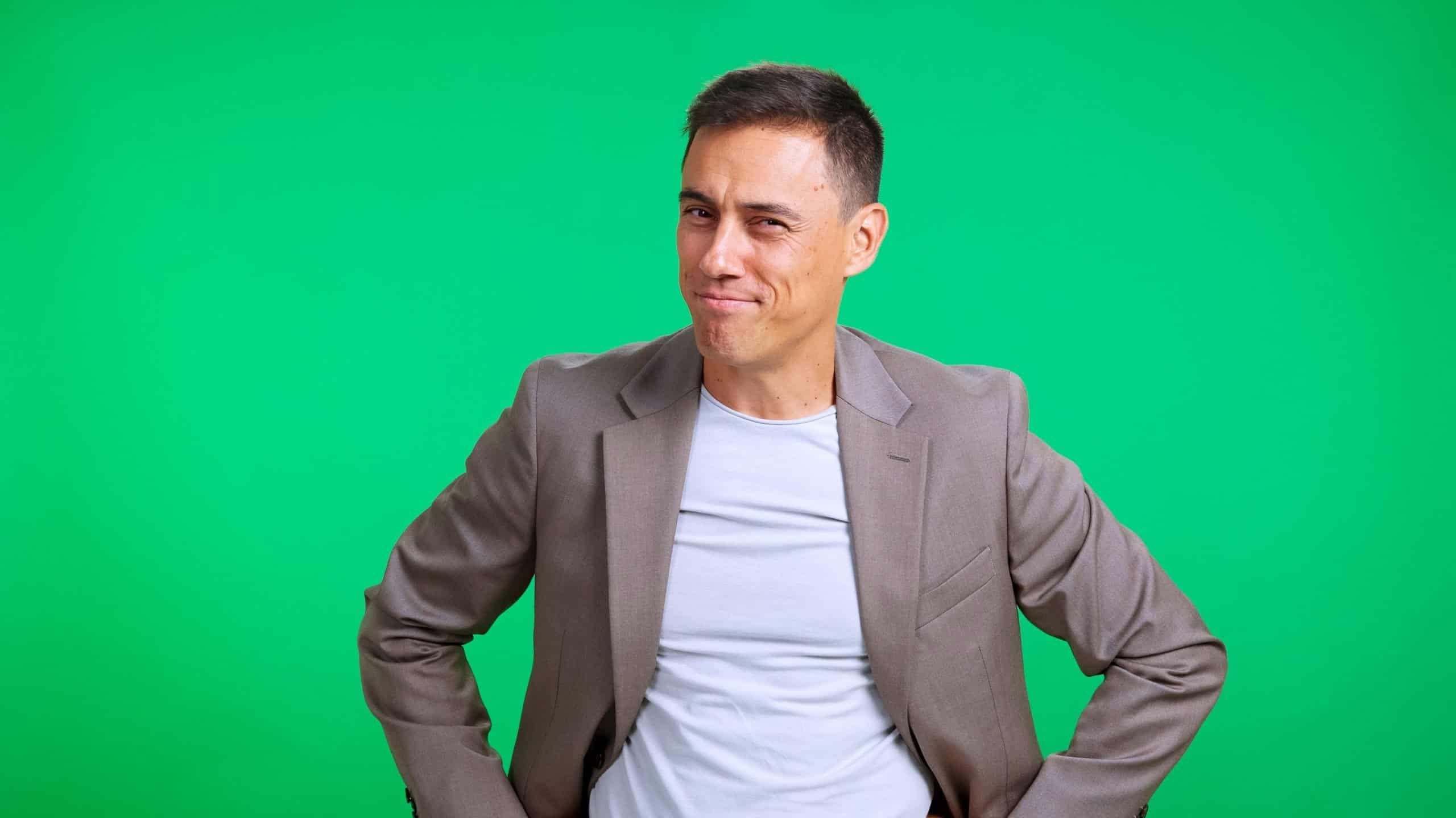 Confident mature man smirking, standing and looking at the camera with a