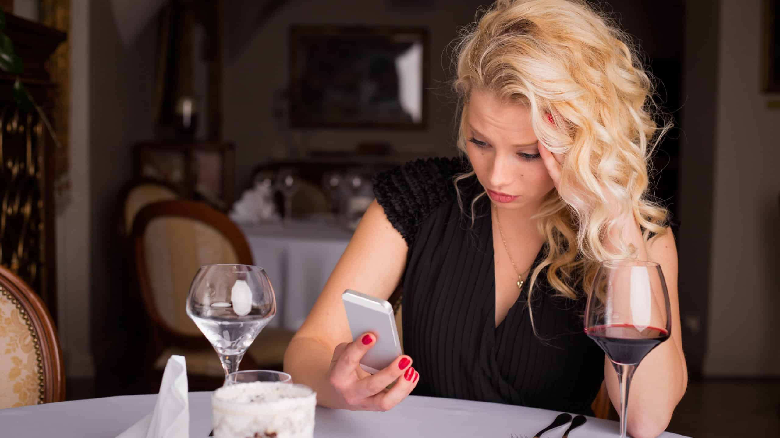 Woman at restaurant looking at her phone